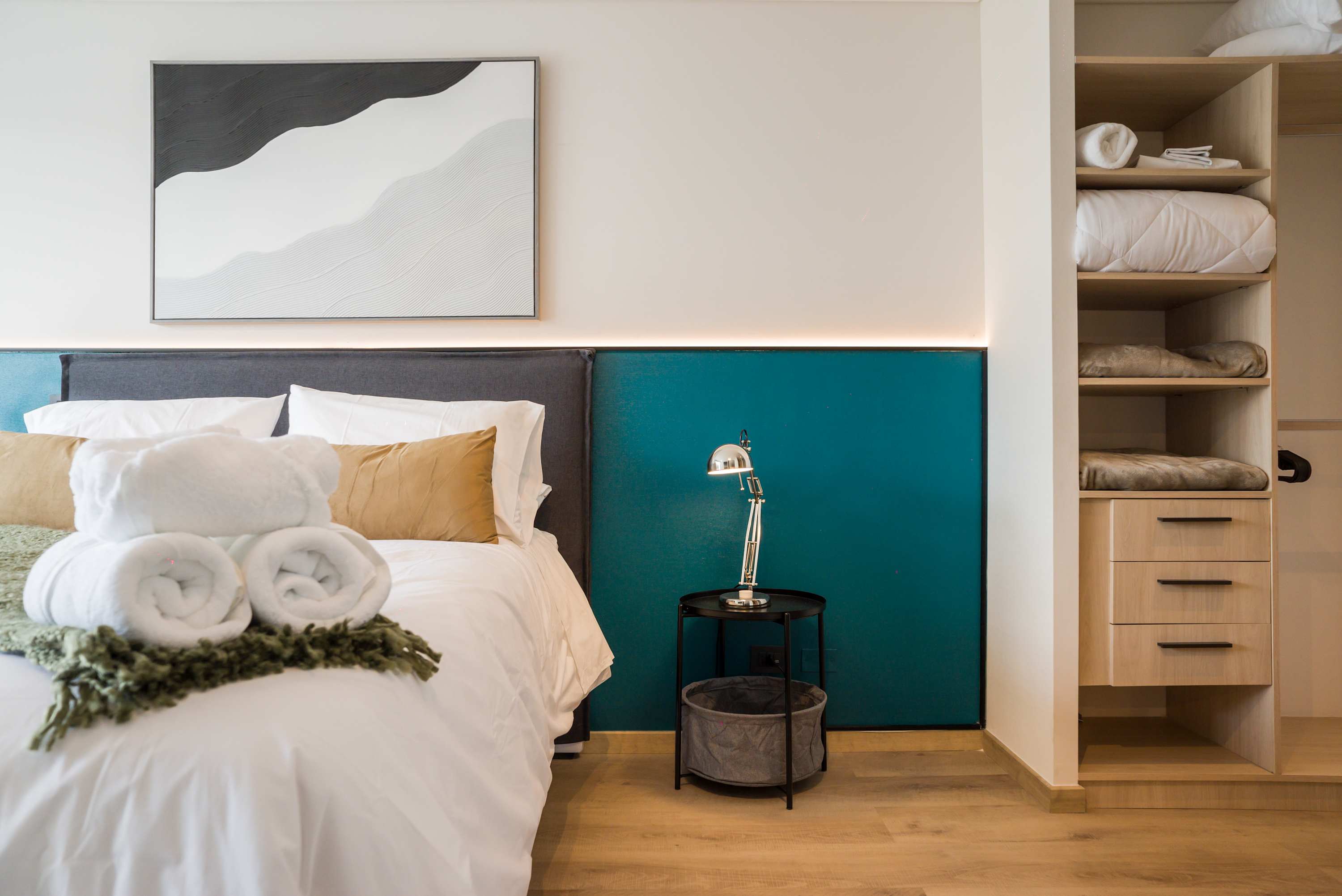 Relax in this stylish bedroom featuring plush bedding, modern decor, and ample storage space.