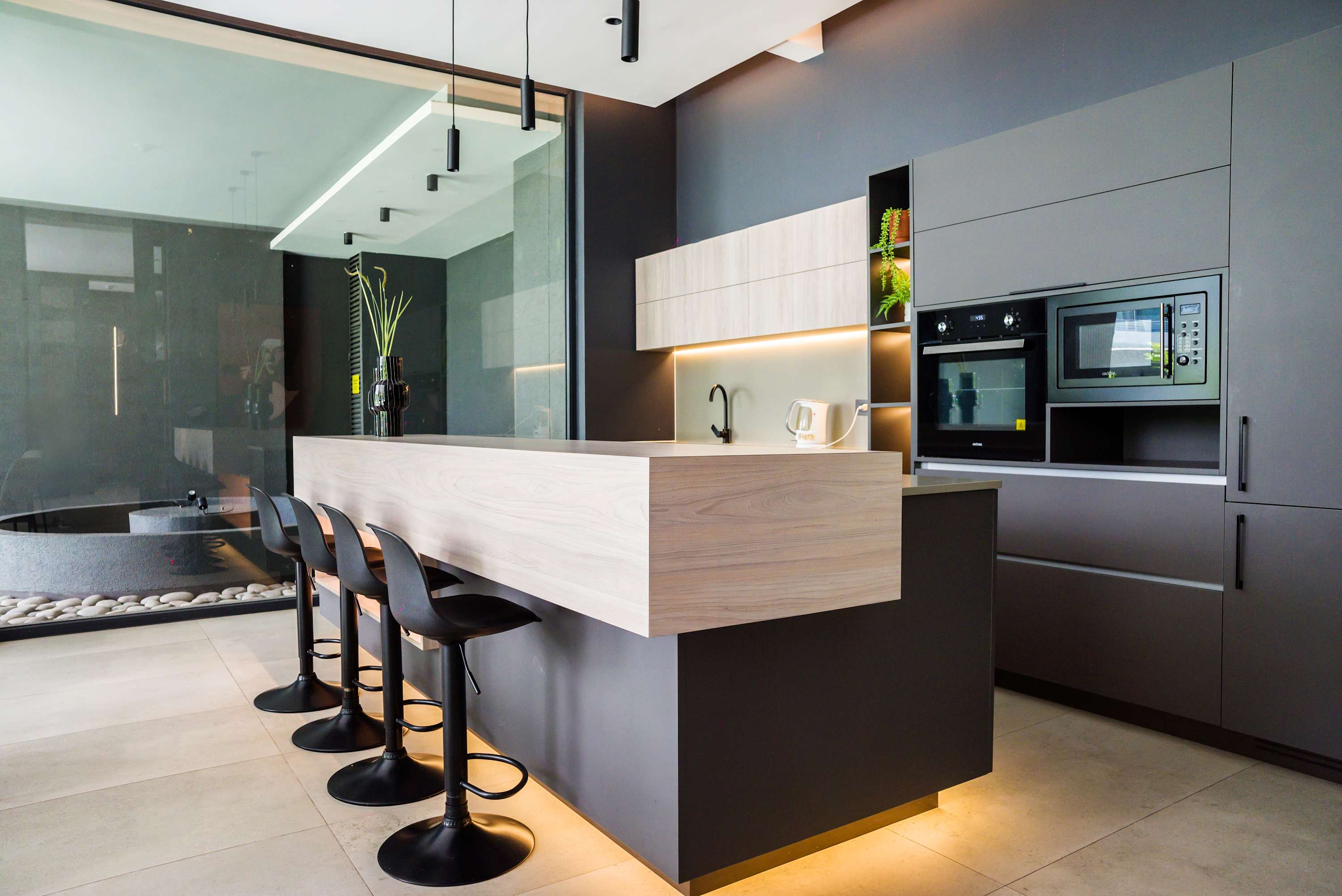 Stylish and modern kitchen area with sleek design and ample seating, perfect for culinary enthusiasts.