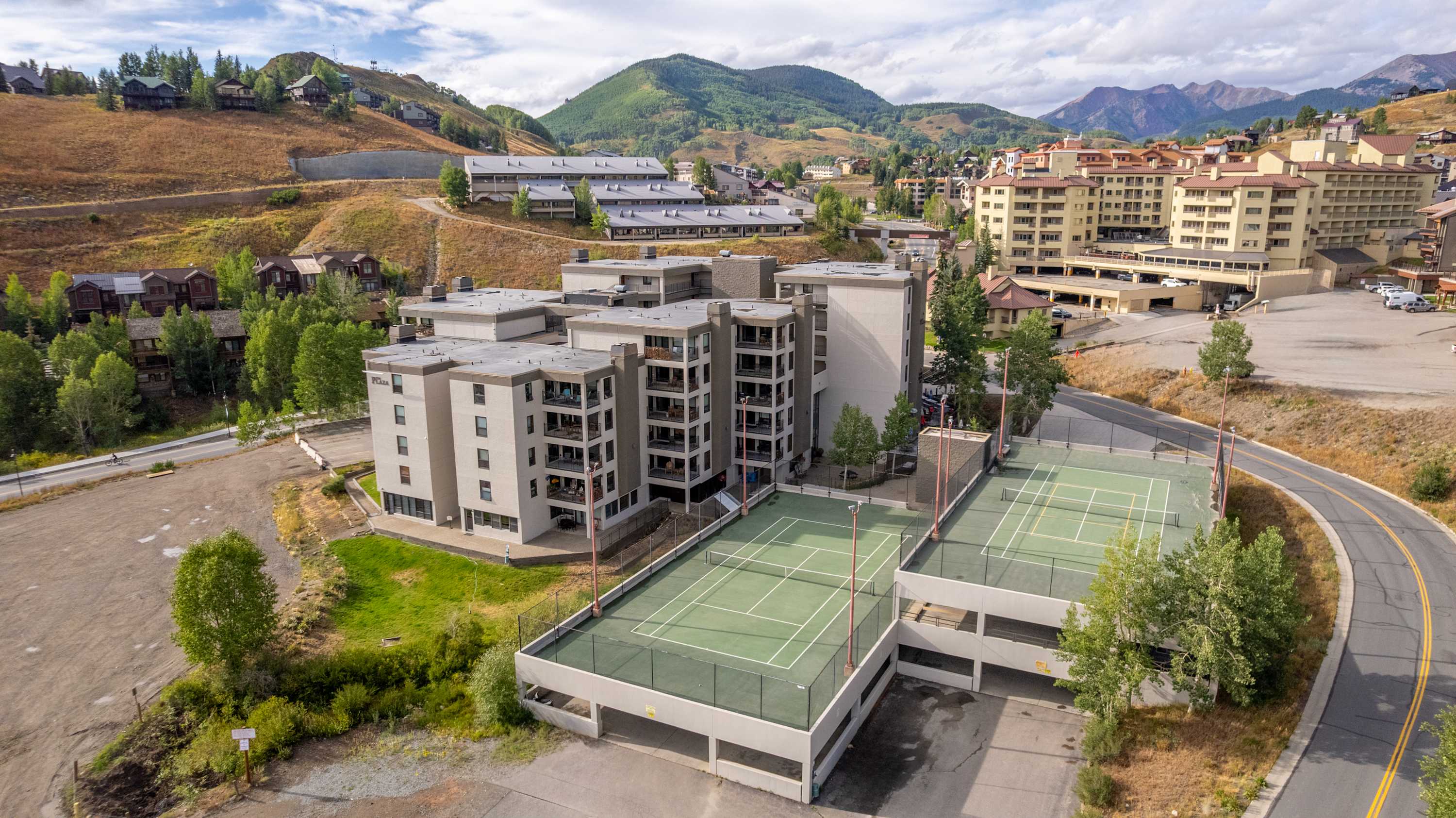 Mountain condo building with balconies overlooking snow-covered slopes and valley views