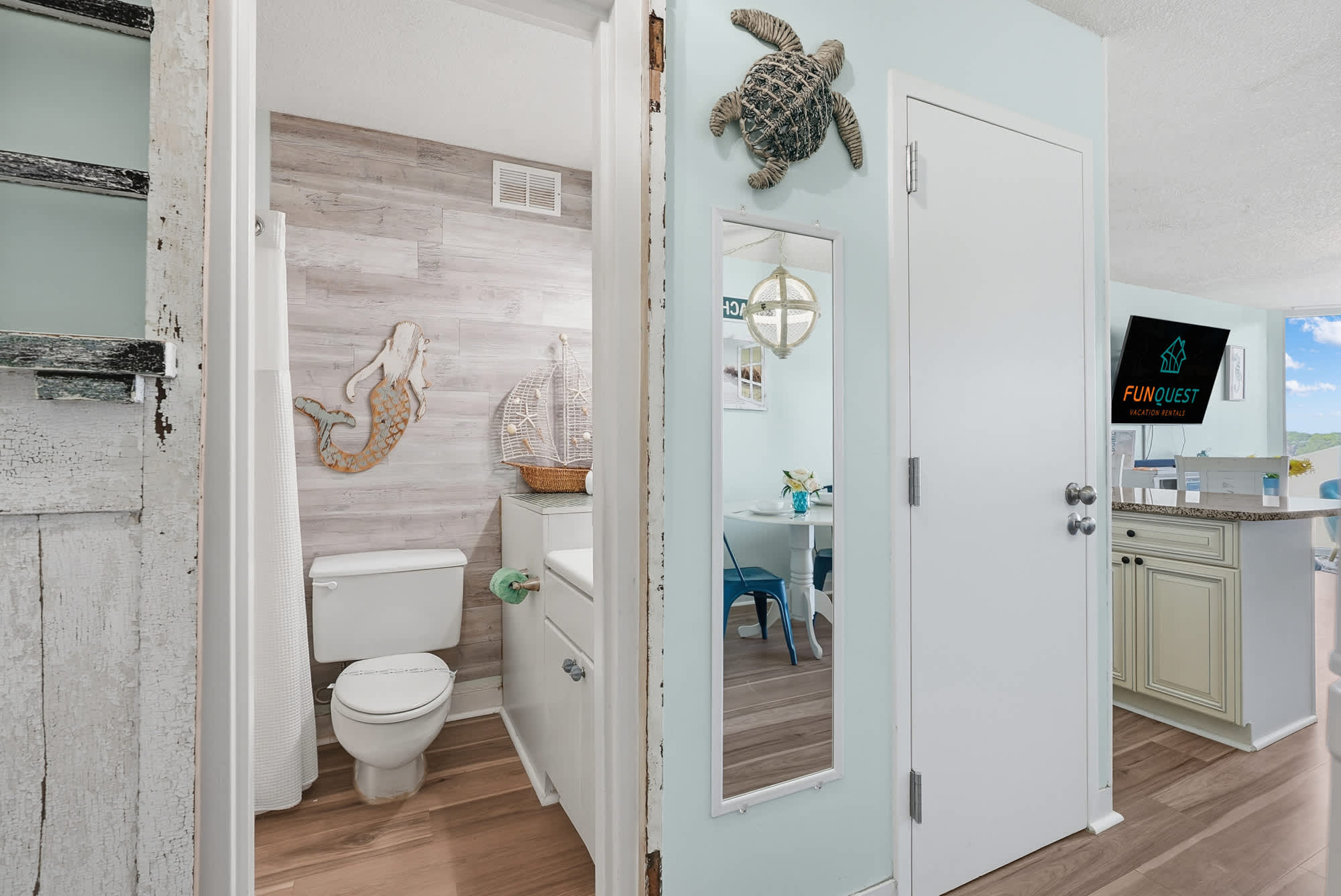 Top Of The Gulf  602 – View of a bathroom and dining area in a vacation rental, featuring light blue walls and wooden accents.