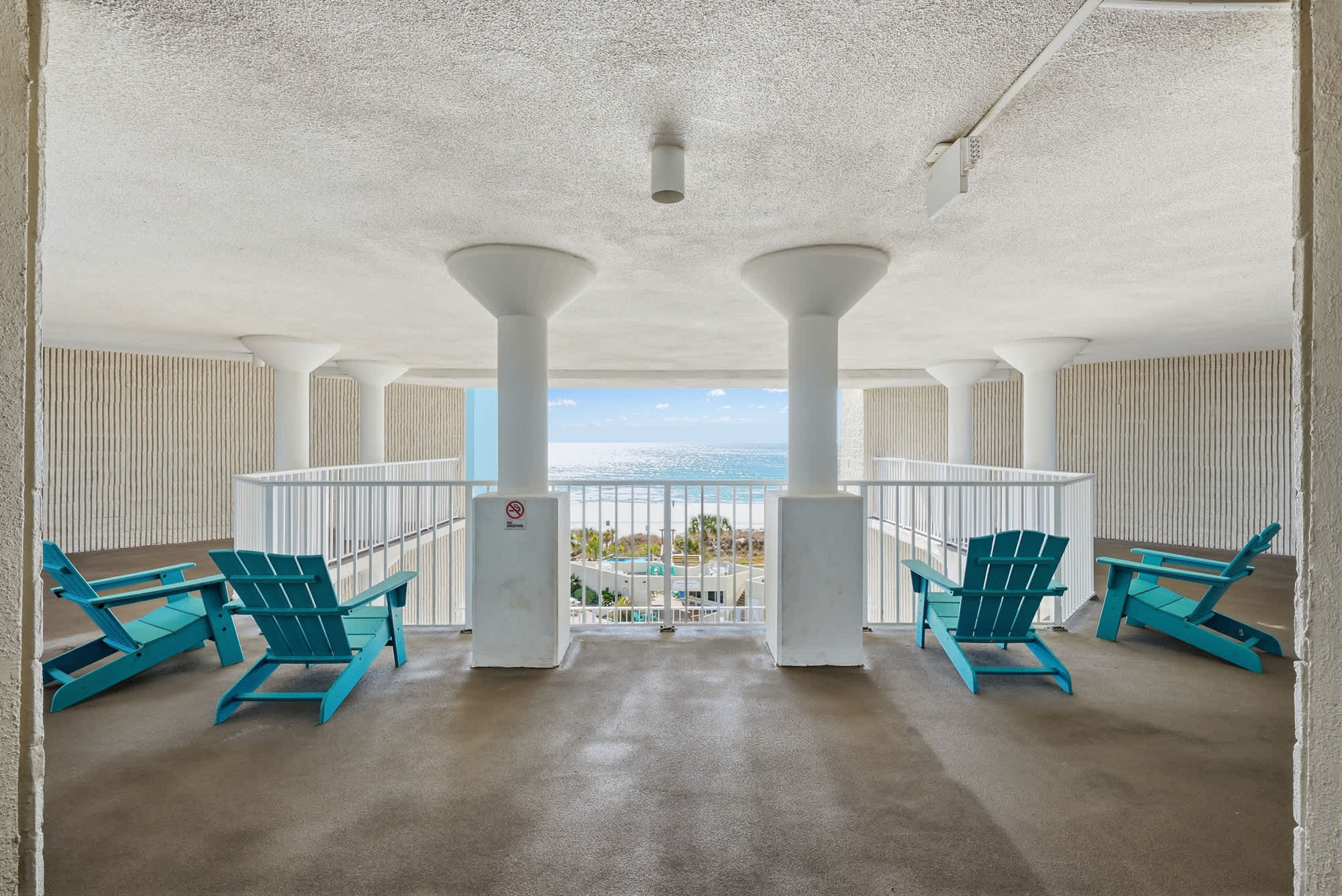 Top Of The Gulf  602 – Outdoor balcony with teal lounge chairs and ocean view.