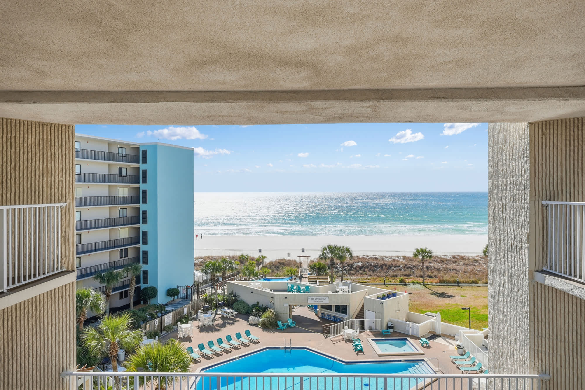 Top Of The Gulf  602 – View from balcony showing a pool area and beachfront.