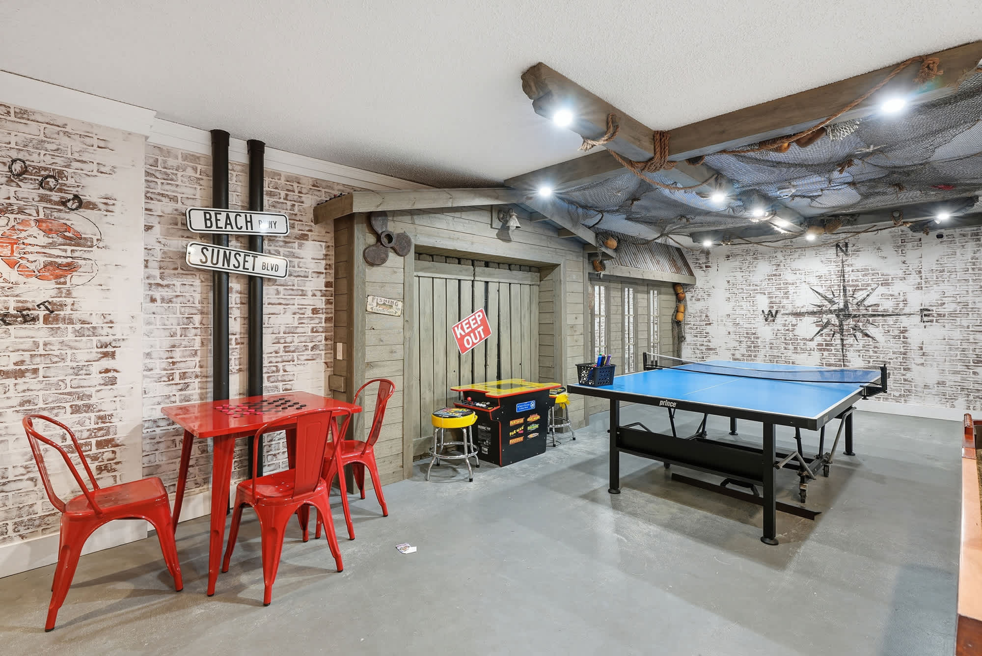 Top Of The Gulf 613 – Game room featuring a ping pong table, red dining set, and brick accent walls.