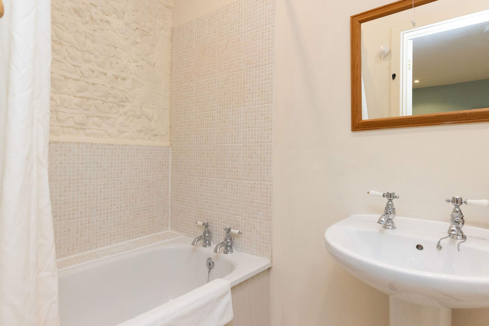 The bathroom has painted exposed brick, continuing the cottage charm.