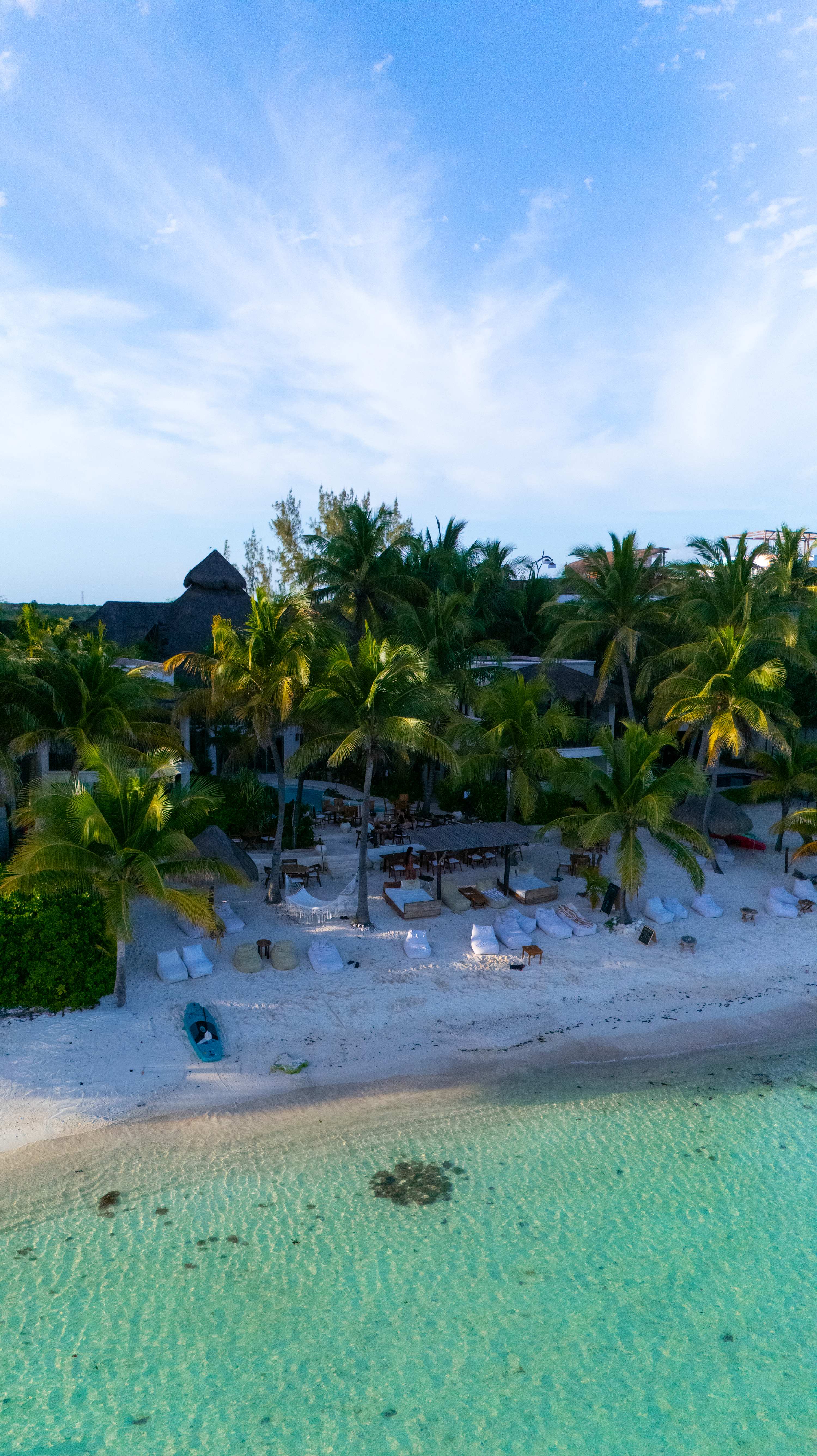Drone view capturing the sea, golden sand, and beach clubs at Mantaray.