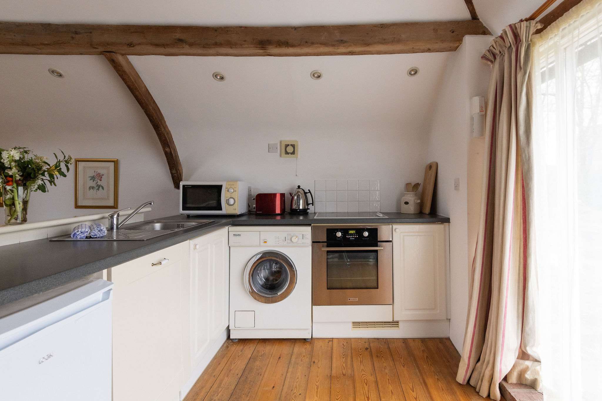Simple kitchen with oven, hob, microwave, and washing machine, everything you need for relaxed stays.