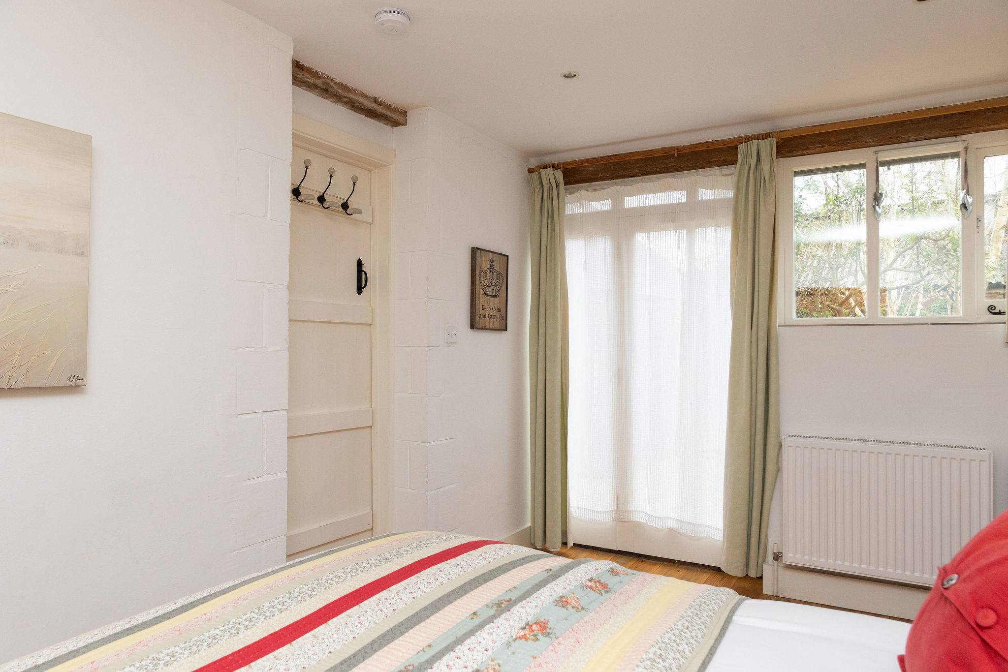 Bright and airy king bedroom with plenty of natural light, storage space and garden views.