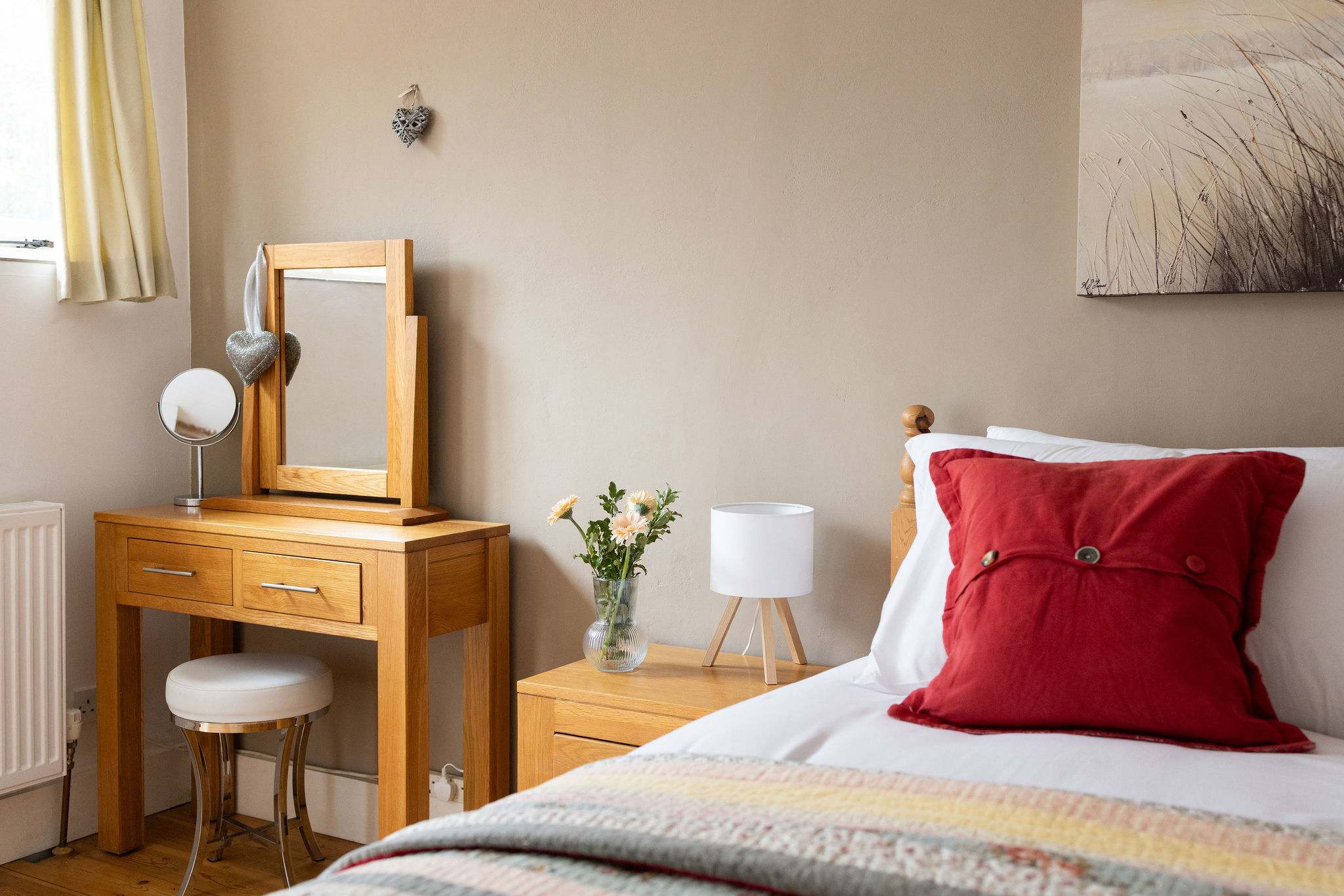 Pine dressing table with mirror and stool adds country charm in Wren Barn's master king room.