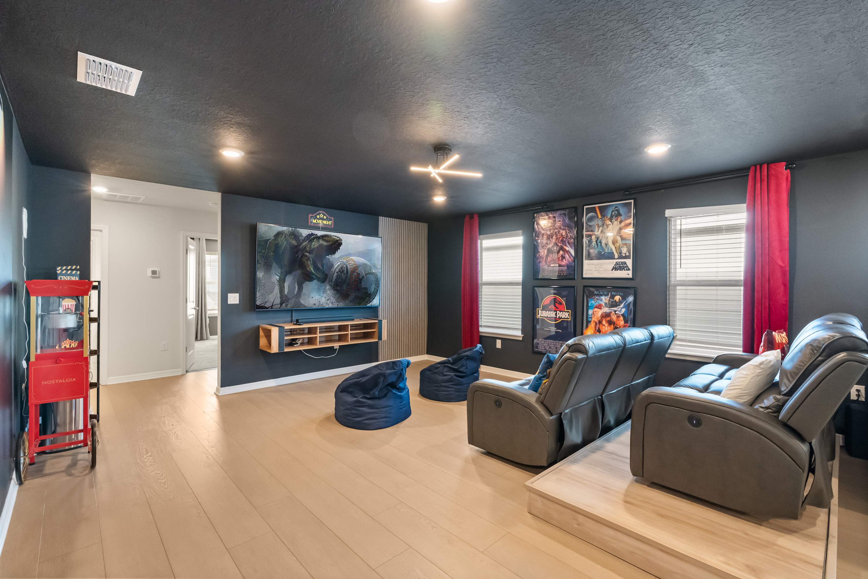 Experience cinematic magic in this private home theater with plush recliners, bean bags, and a vintage popcorn machine for unforgettable movie nights.