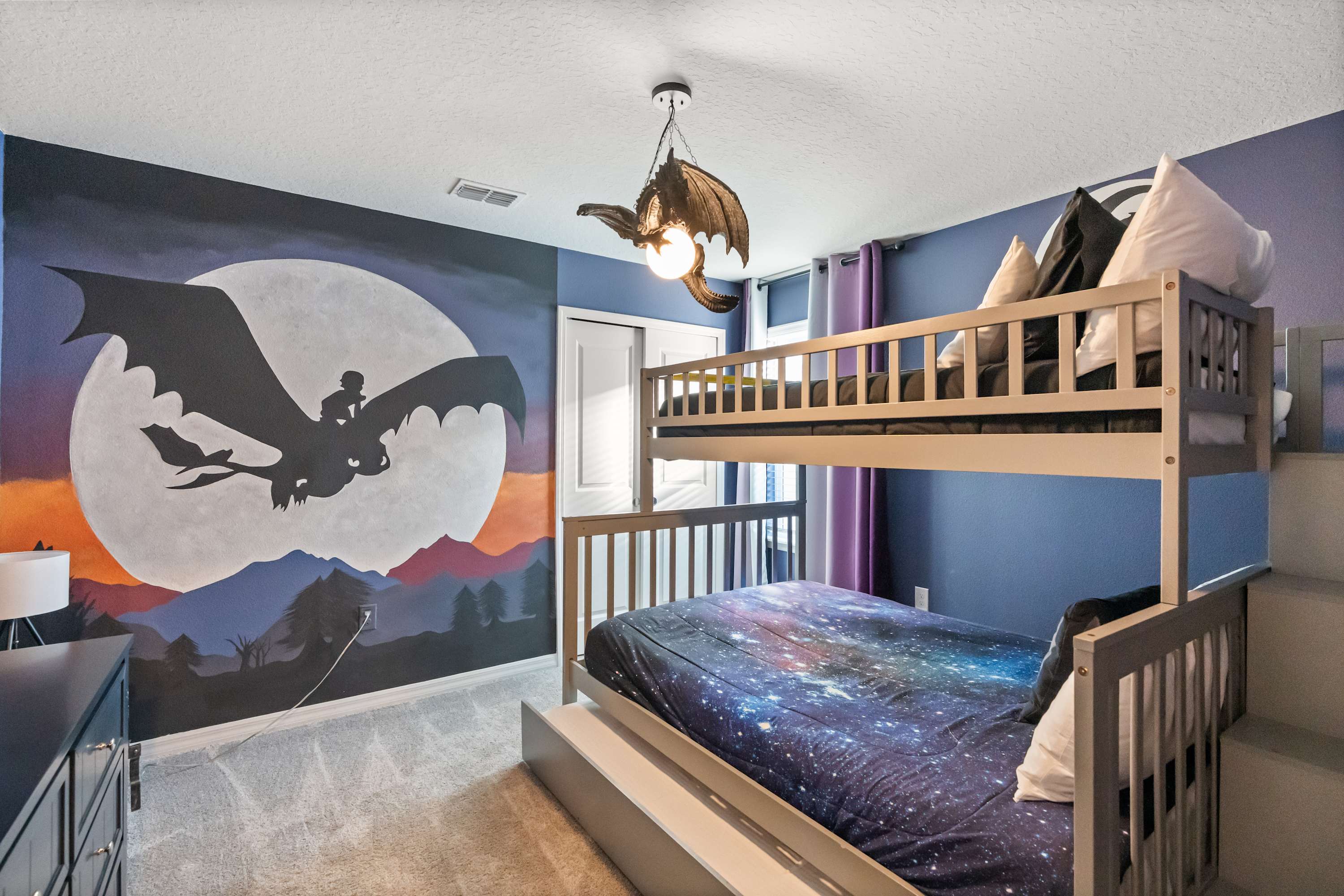 Experience a magical stay in this dragon-themed room with a stunning mural and cozy bunk beds, perfect for fantasy lovers.