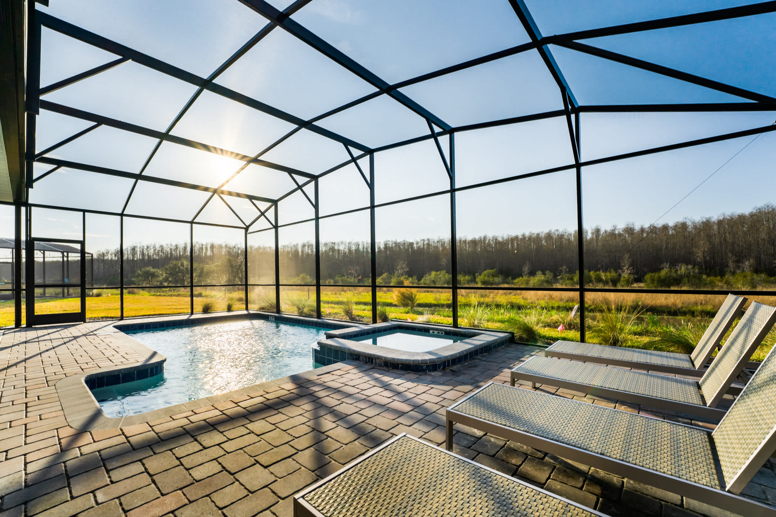 Relax in your private screened-in pool and hot tub with stunning natural views, perfect for unwinding after a day of adventure.