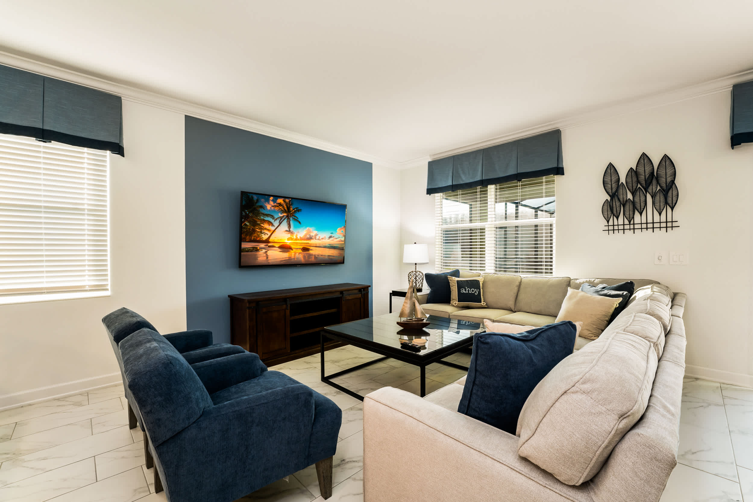 Relax in this elegant living room with plush seating and a large TV, perfect for family gatherings and movie nights.