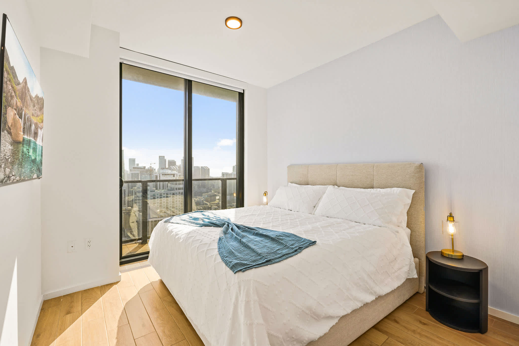 Relax in a cozy bedroom with stunning city views and natural light.