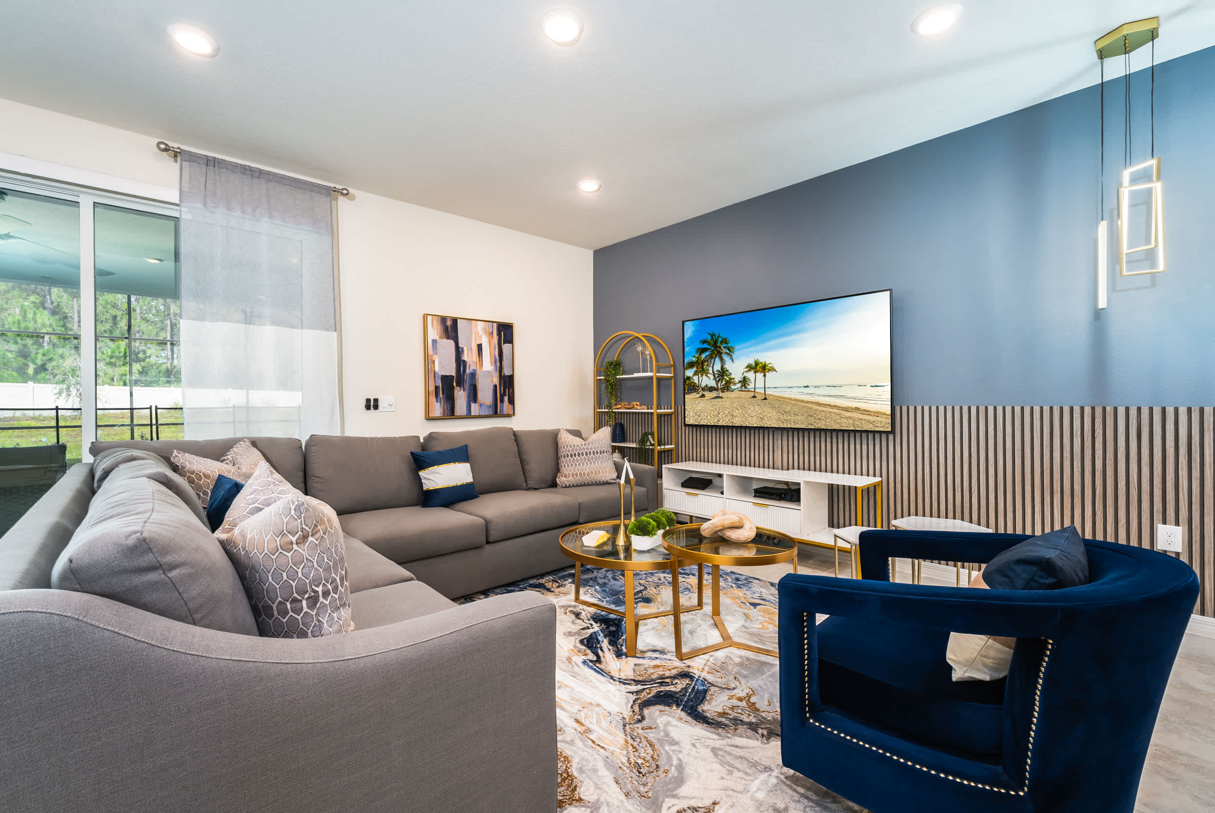 Relax in this stylish living room with a plush sectional, chic decor, and a large TV, perfect for unwinding after a day of adventure.