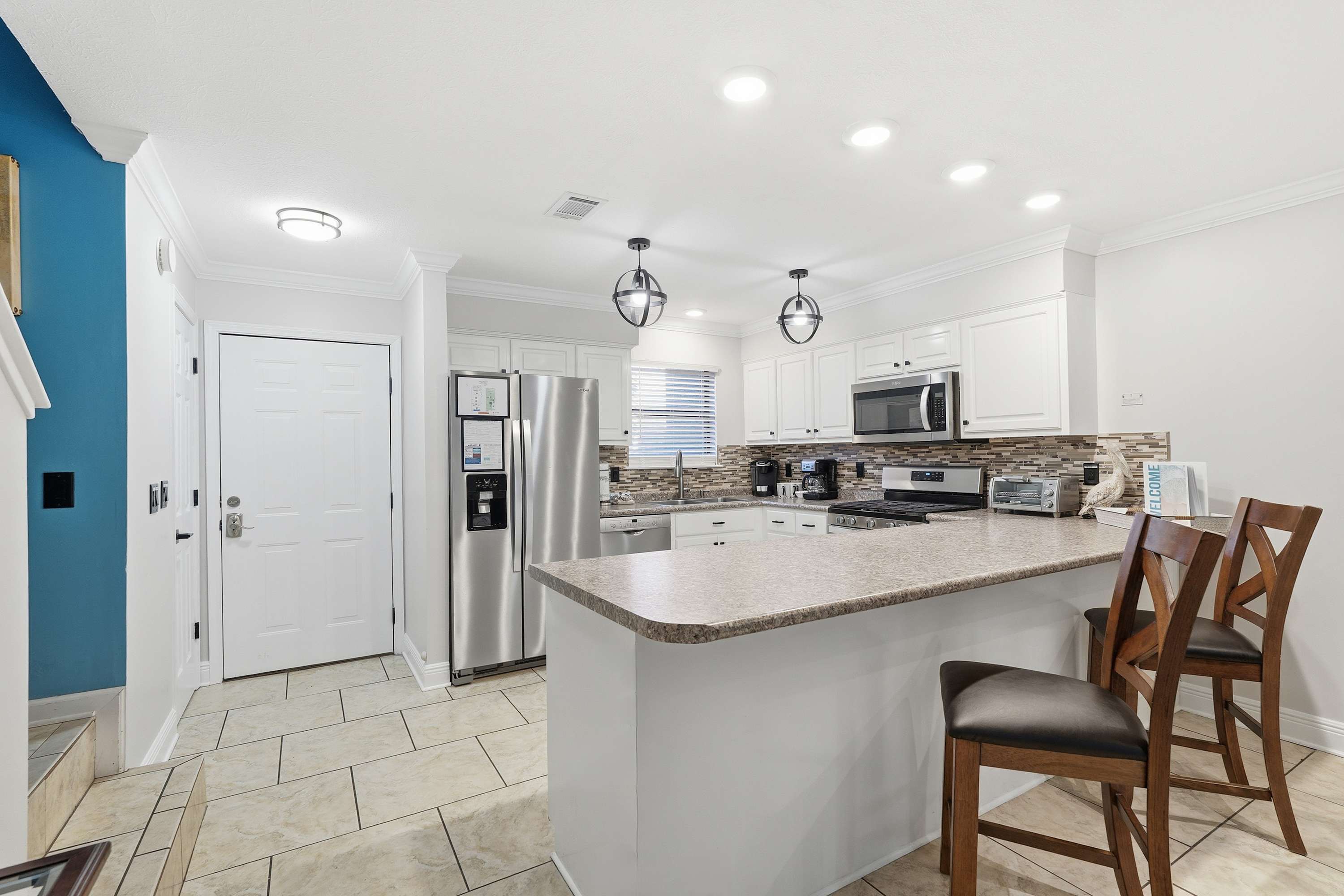 135 Grande Island Blvd – Modern kitchen with stainless steel appliances, granite countertops, and bar seating.