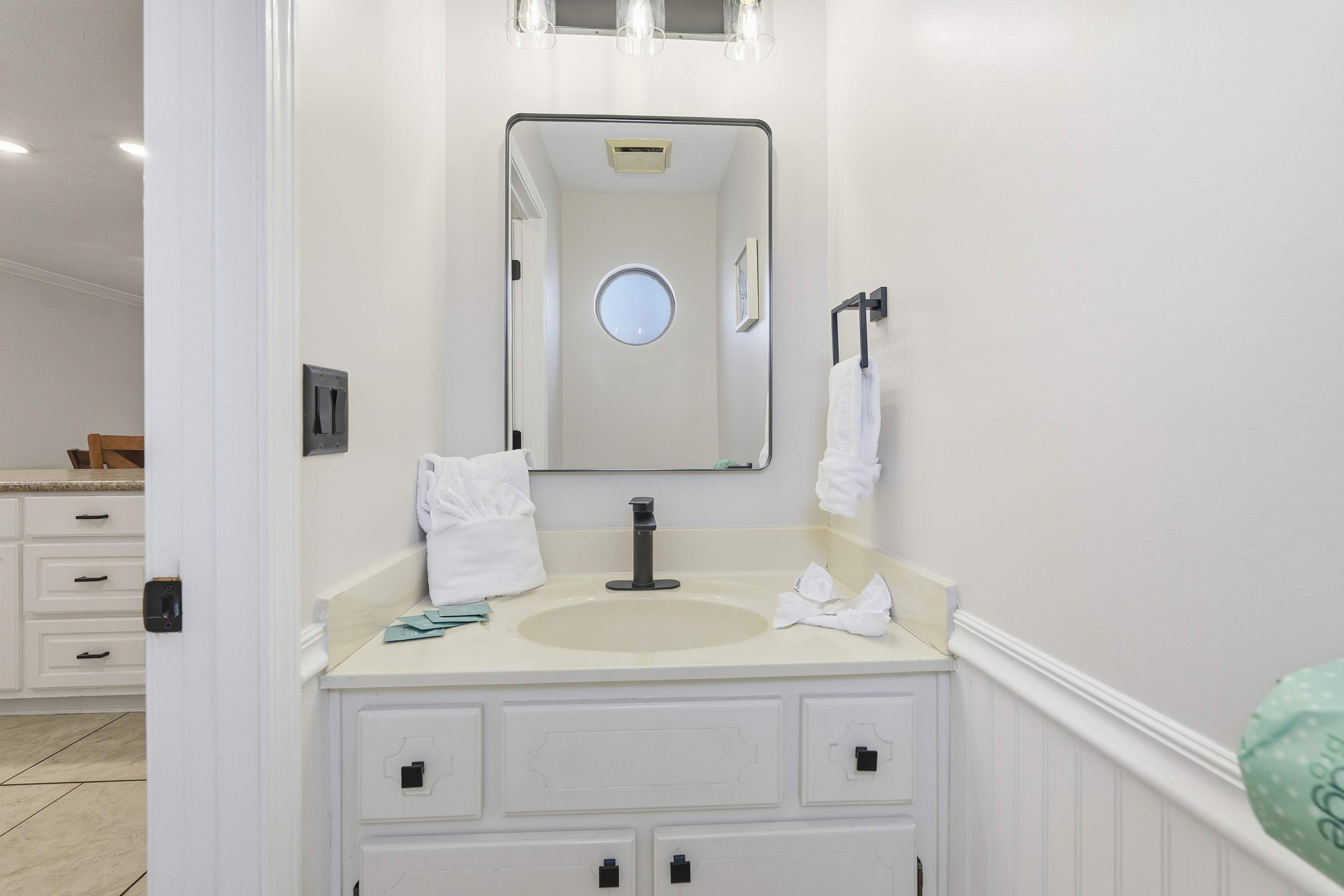 135 Grande Island Blvd – Bathroom with sink, large mirror, white towels, and light tile flooring.