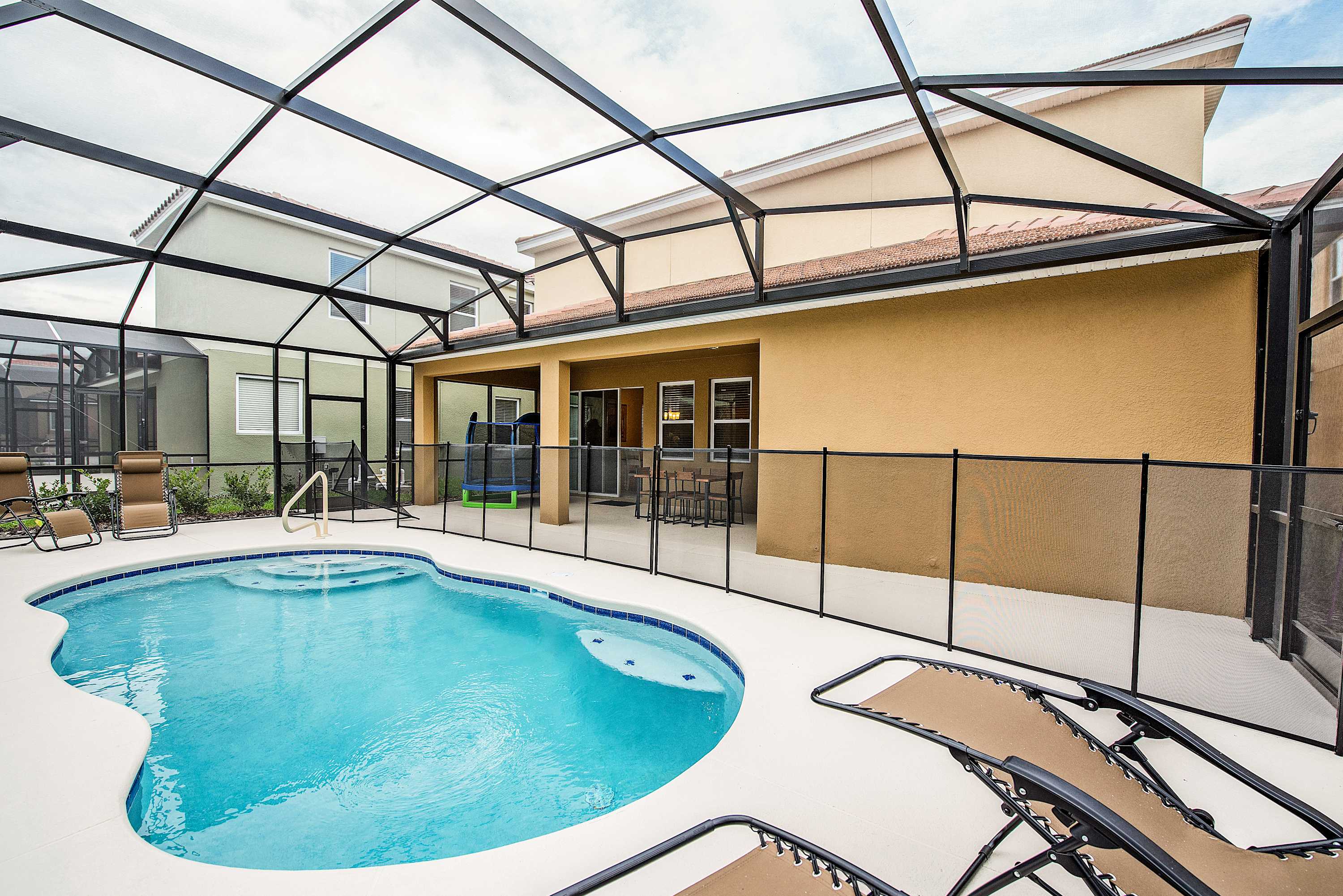 Relax by your private pool with a safety fence, lounge chairs, and a covered patio perfect for family fun and relaxation.