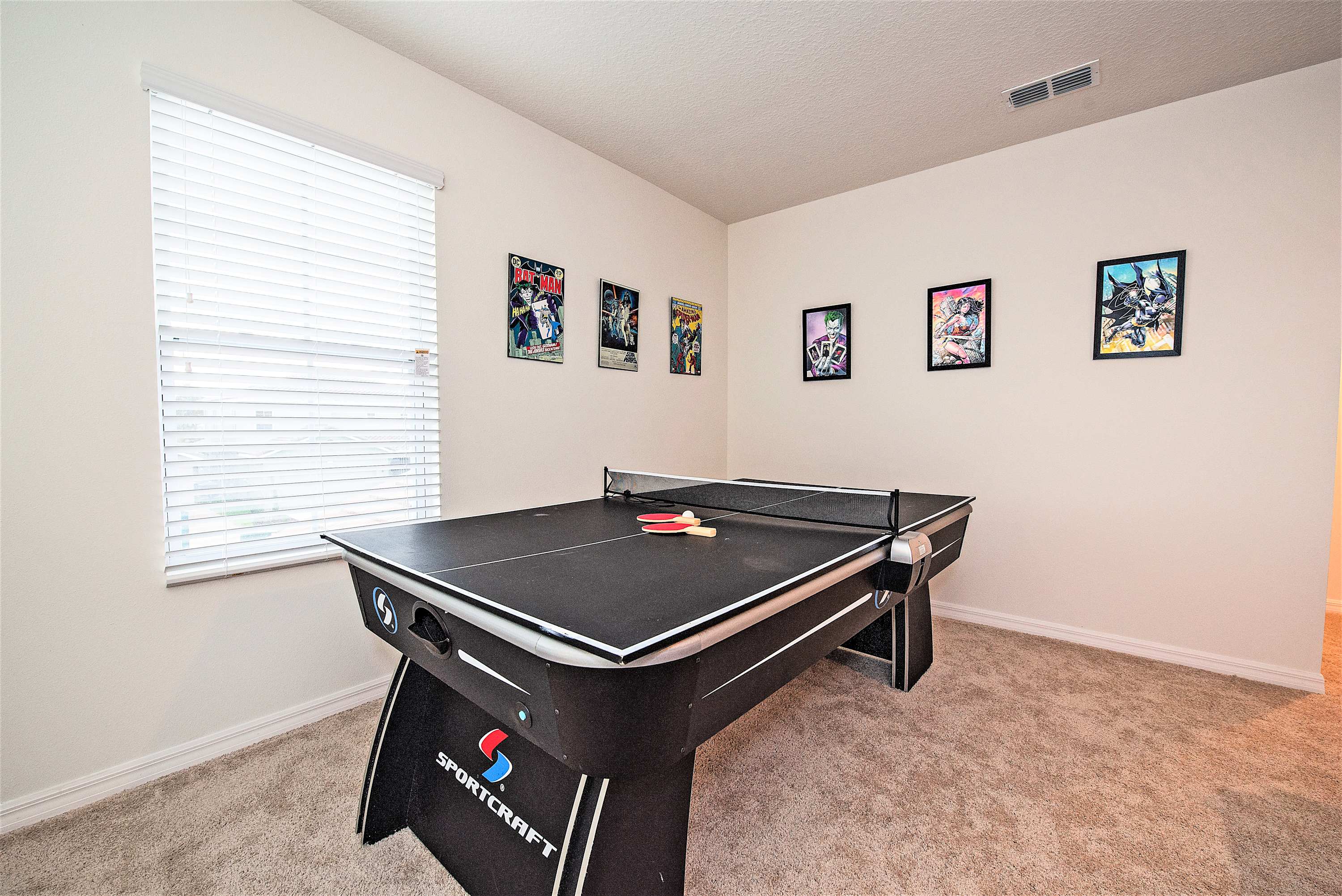 Enjoy a fun-filled game room with a ping pong table and vibrant comic art, perfect for family tournaments.