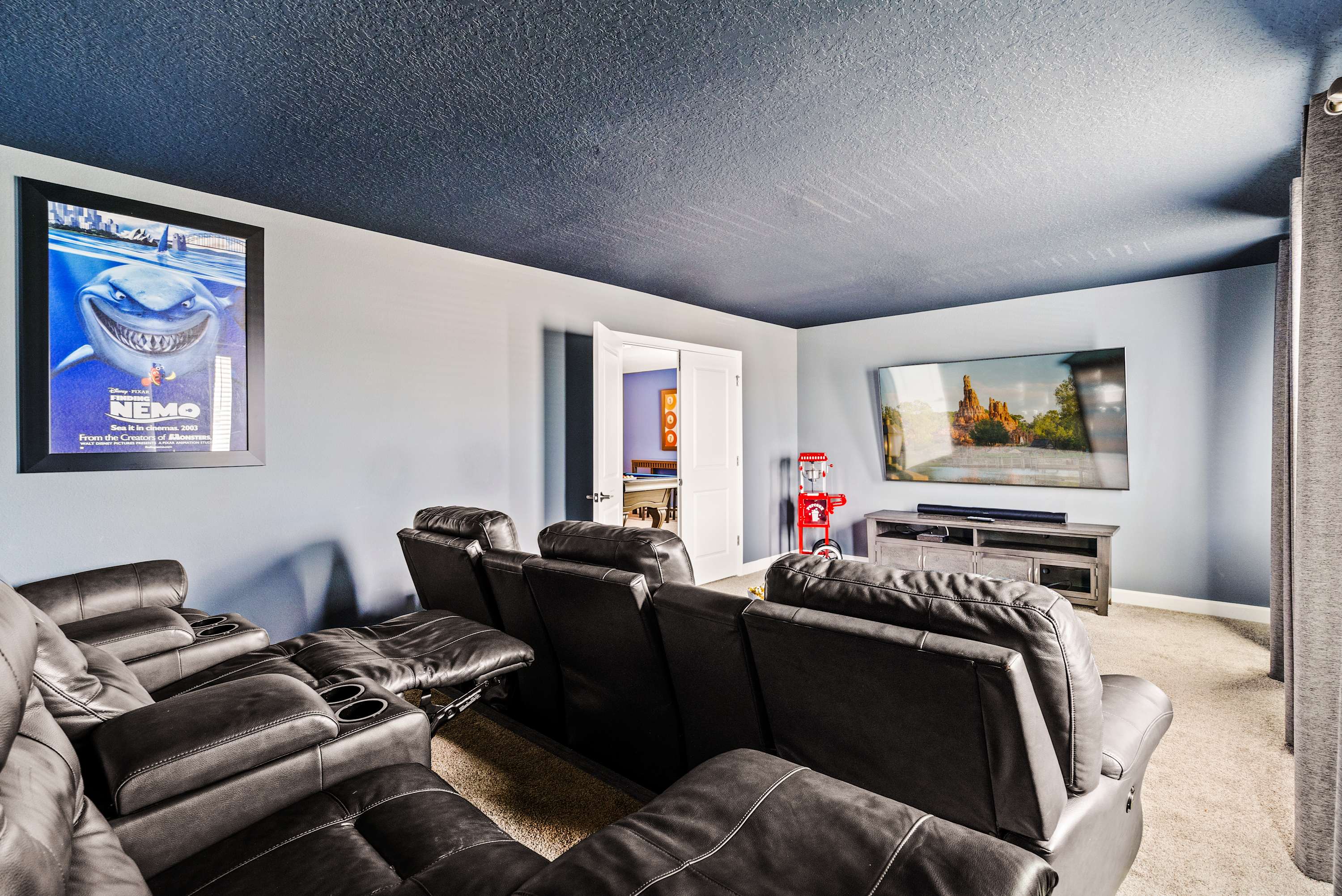 Enjoy movie nights in your private home theater with plush recliners and a popcorn machine for the ultimate cinematic experience.
