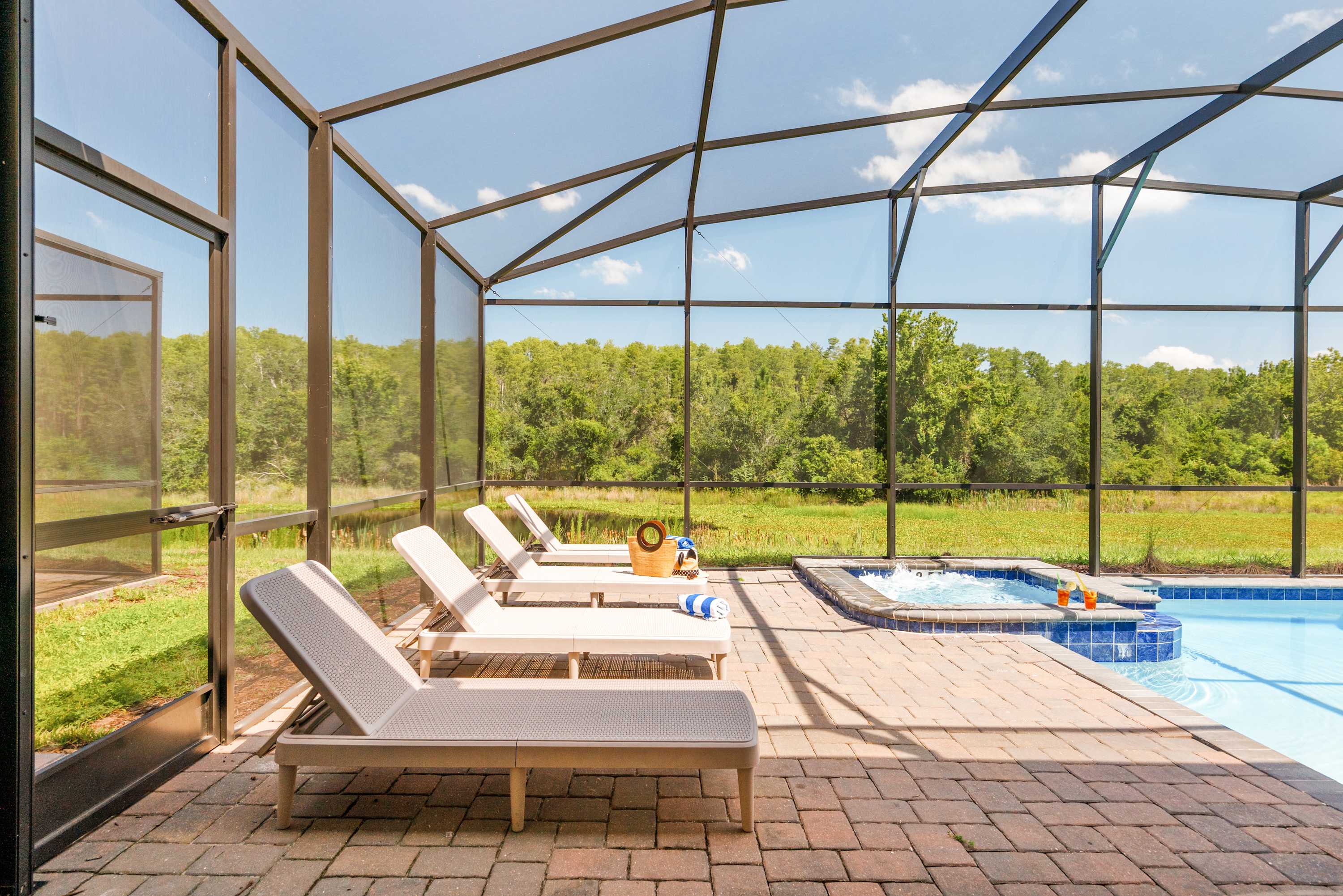 Relax in your private screened-in pool area with a hot tub, surrounded by serene nature and perfect for unwinding.