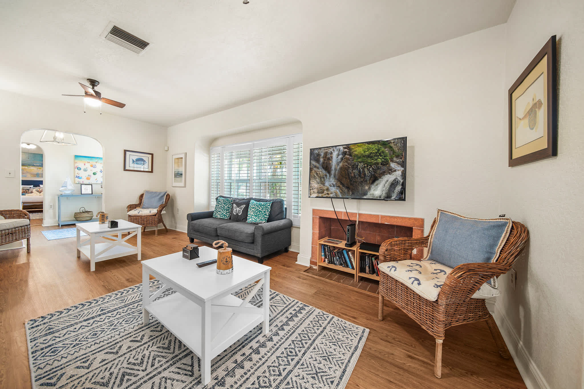 Relax in this inviting living room with a comfy sofa, charming decor, and a large TV for entertainment.