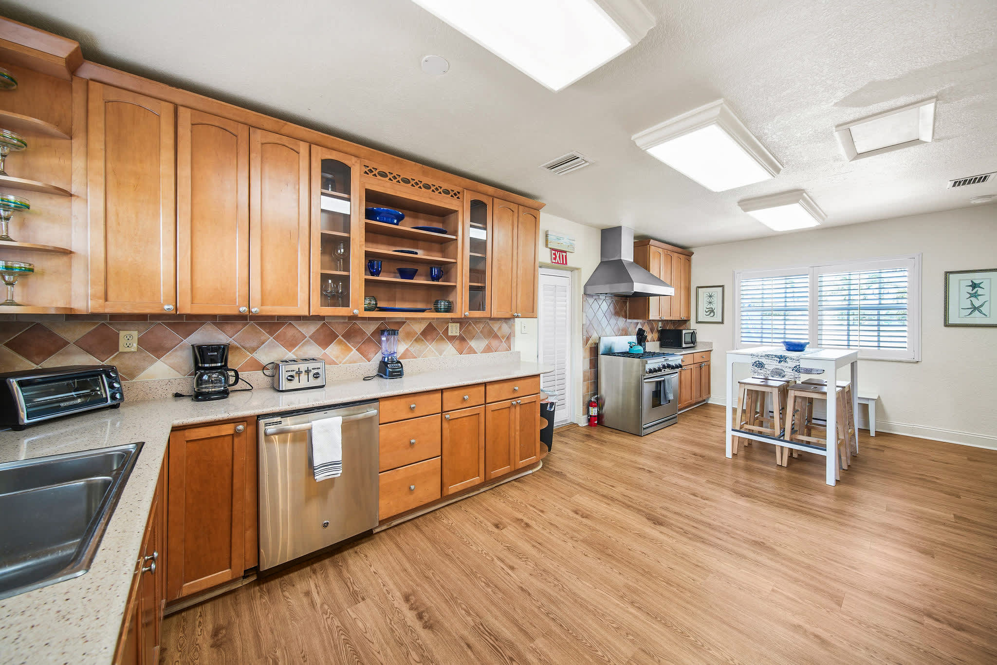 Enjoy cooking in this spacious kitchen with modern appliances and a cozy breakfast bar, perfect for family gatherings.