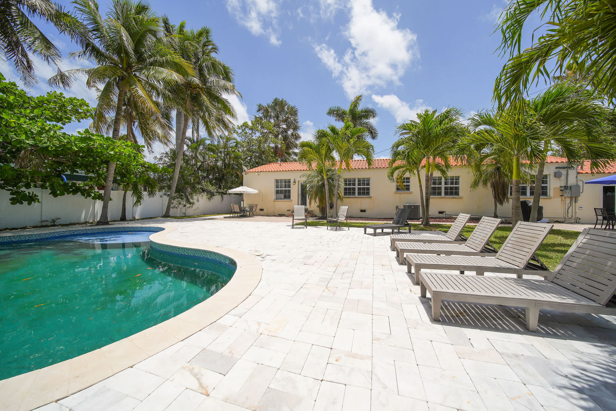 Relax by your private pool oasis surrounded by lush palms and enjoy the sun on comfortable loungers. Perfect for unwinding in a tropical paradise.
