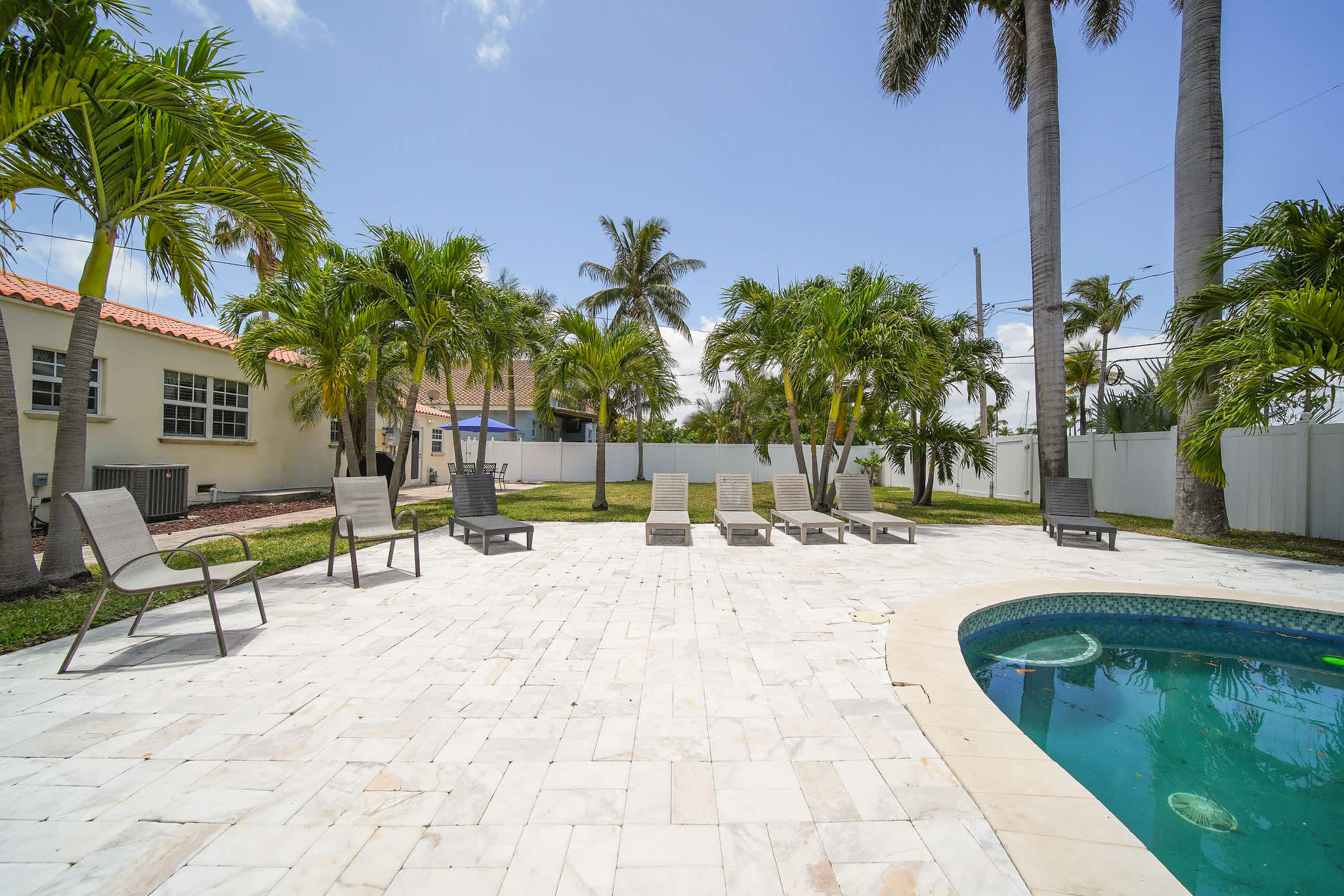 Relax by the private pool in this tropical oasis, complete with palm trees and ample lounge seating.