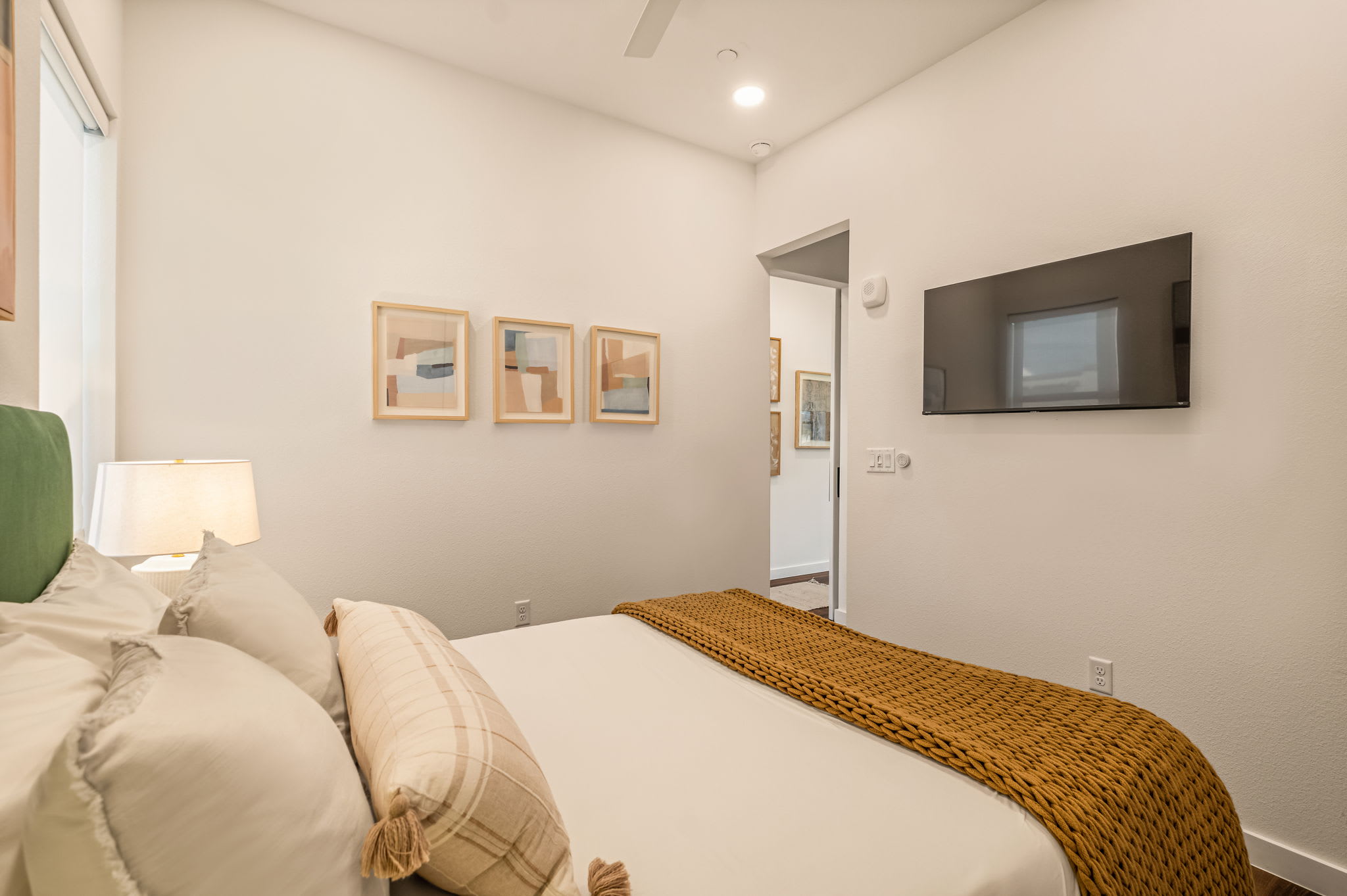 Bedroom with queen bed and mounted TV