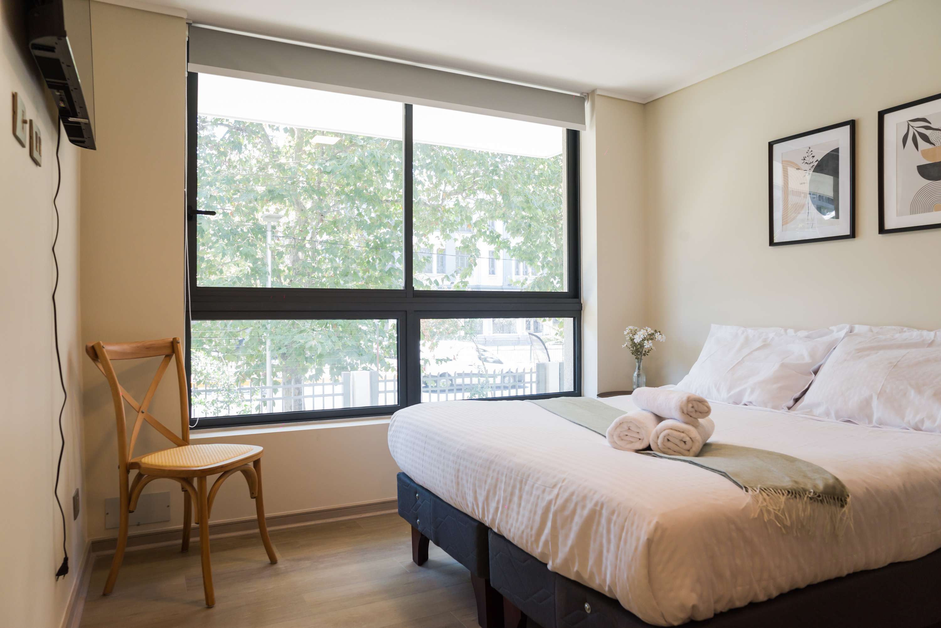 Cozy bedroom with natural light and comfortable bedding, perfect for a restful stay.