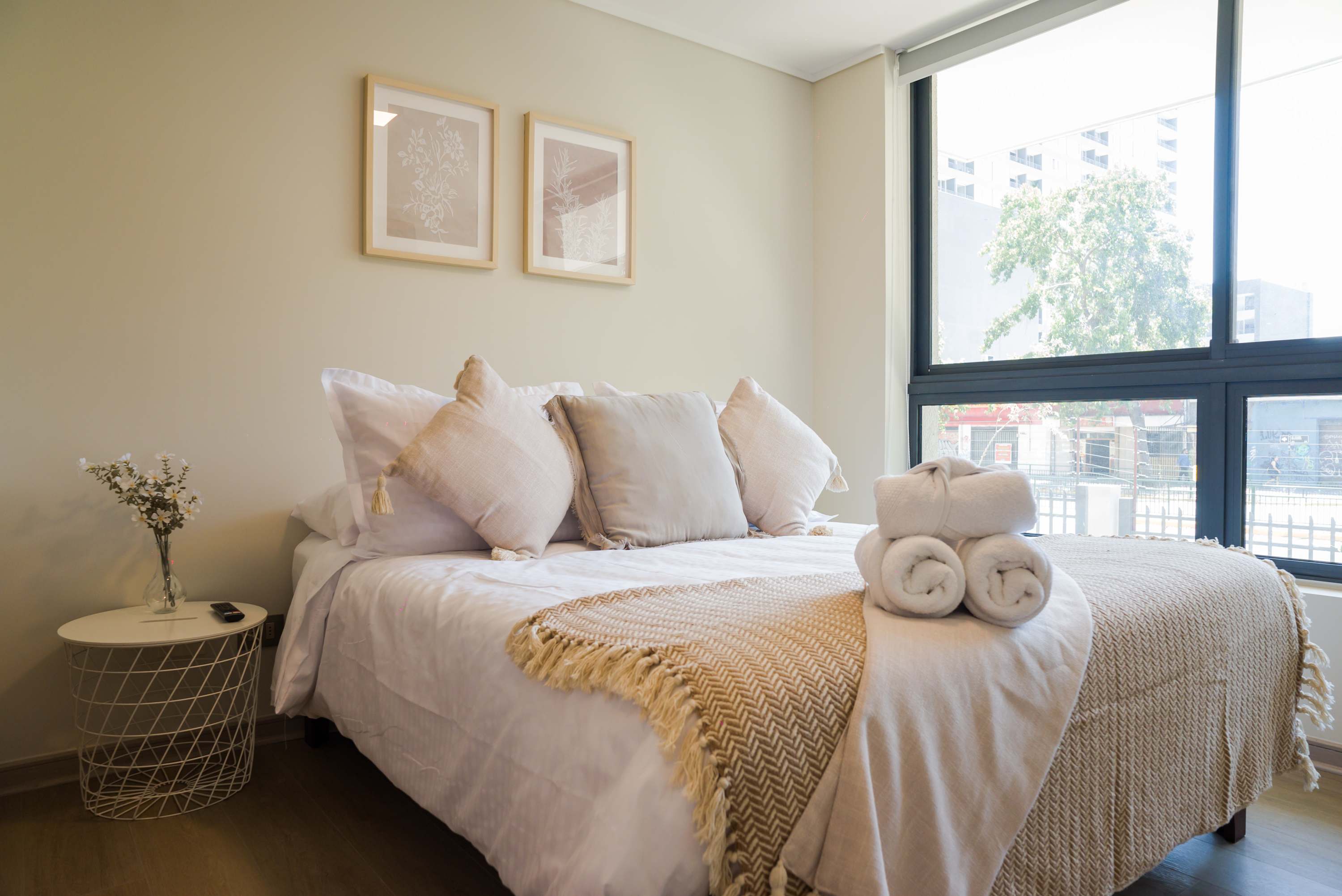 Relax in this bright and cozy bedroom with plush bedding and natural light, perfect for a restful stay.