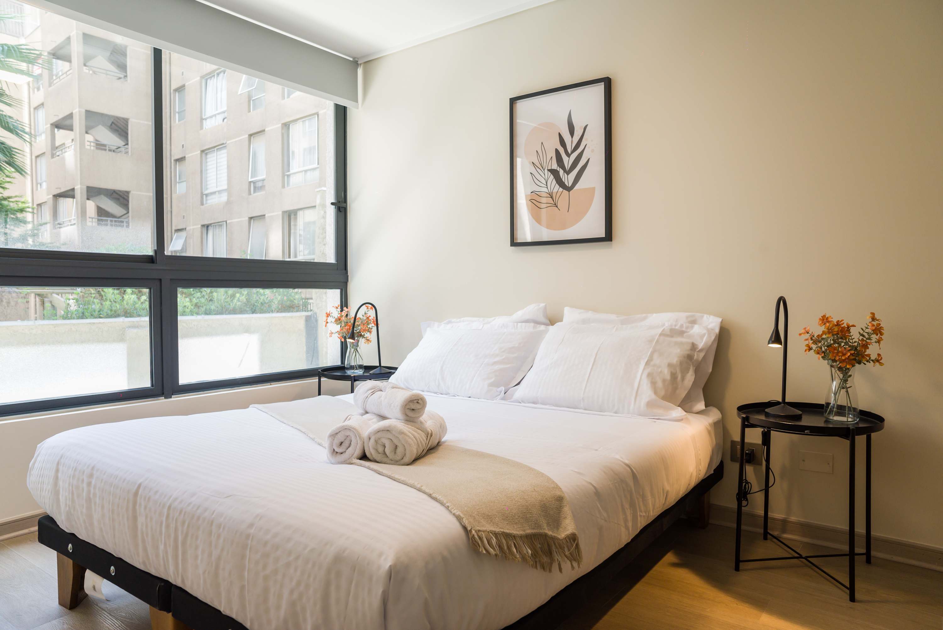 Cozy bedroom with natural light and modern decor, perfect for a relaxing stay in the heart of the city.