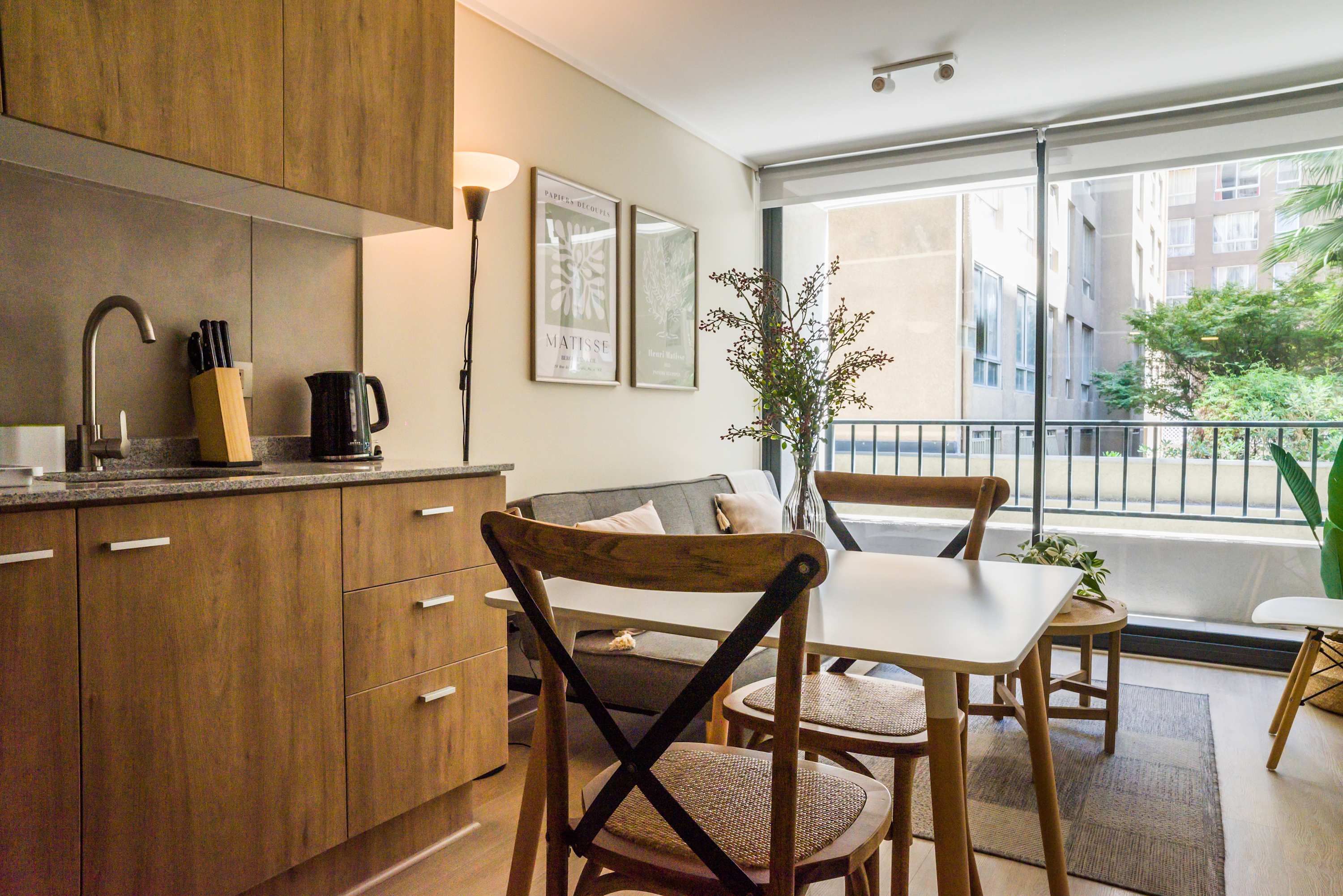 Bright and cozy living space with modern kitchenette and large windows overlooking the cityscape.