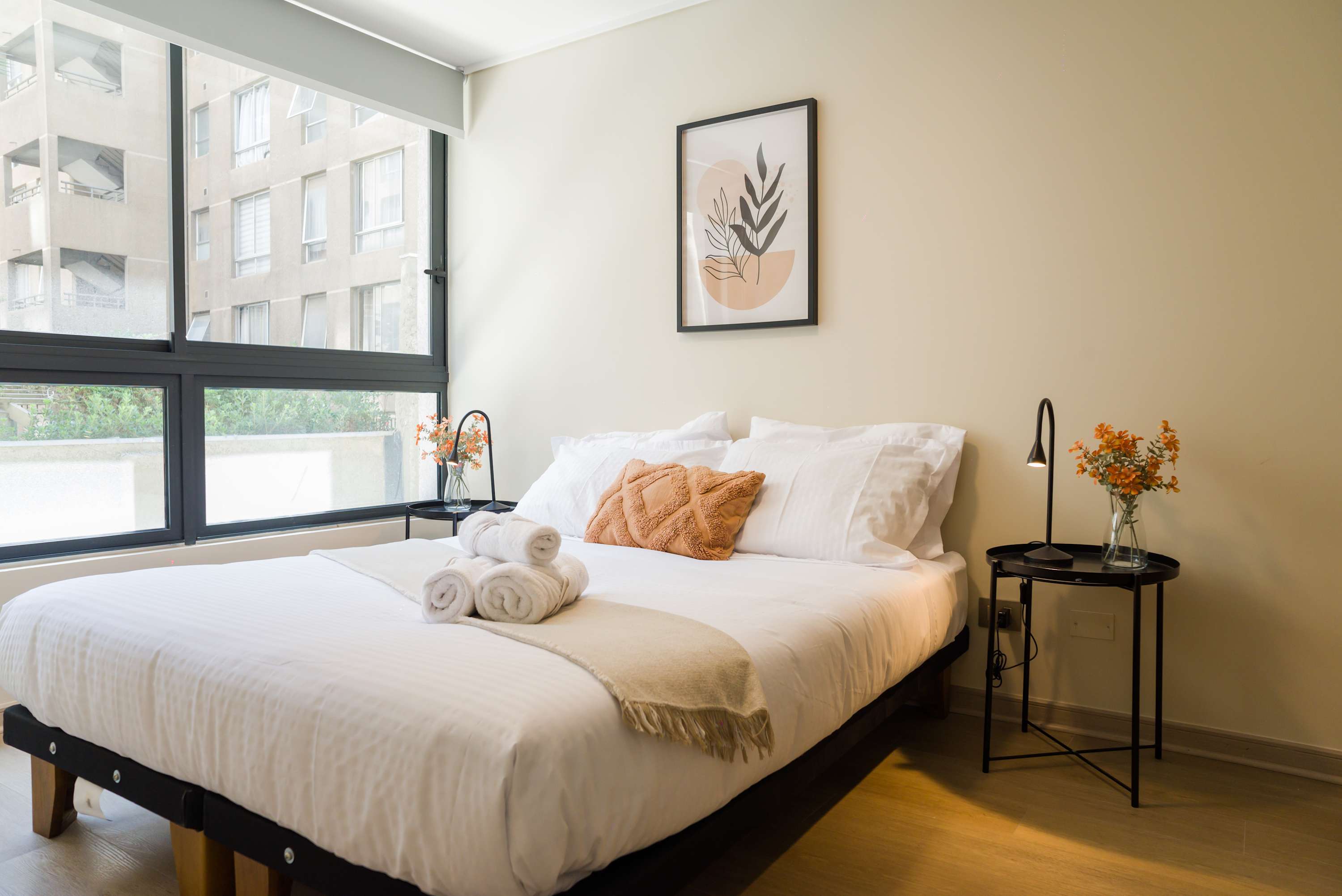 Relax in this bright and cozy bedroom with large windows and stylish decor, perfect for unwinding after a day exploring the city.