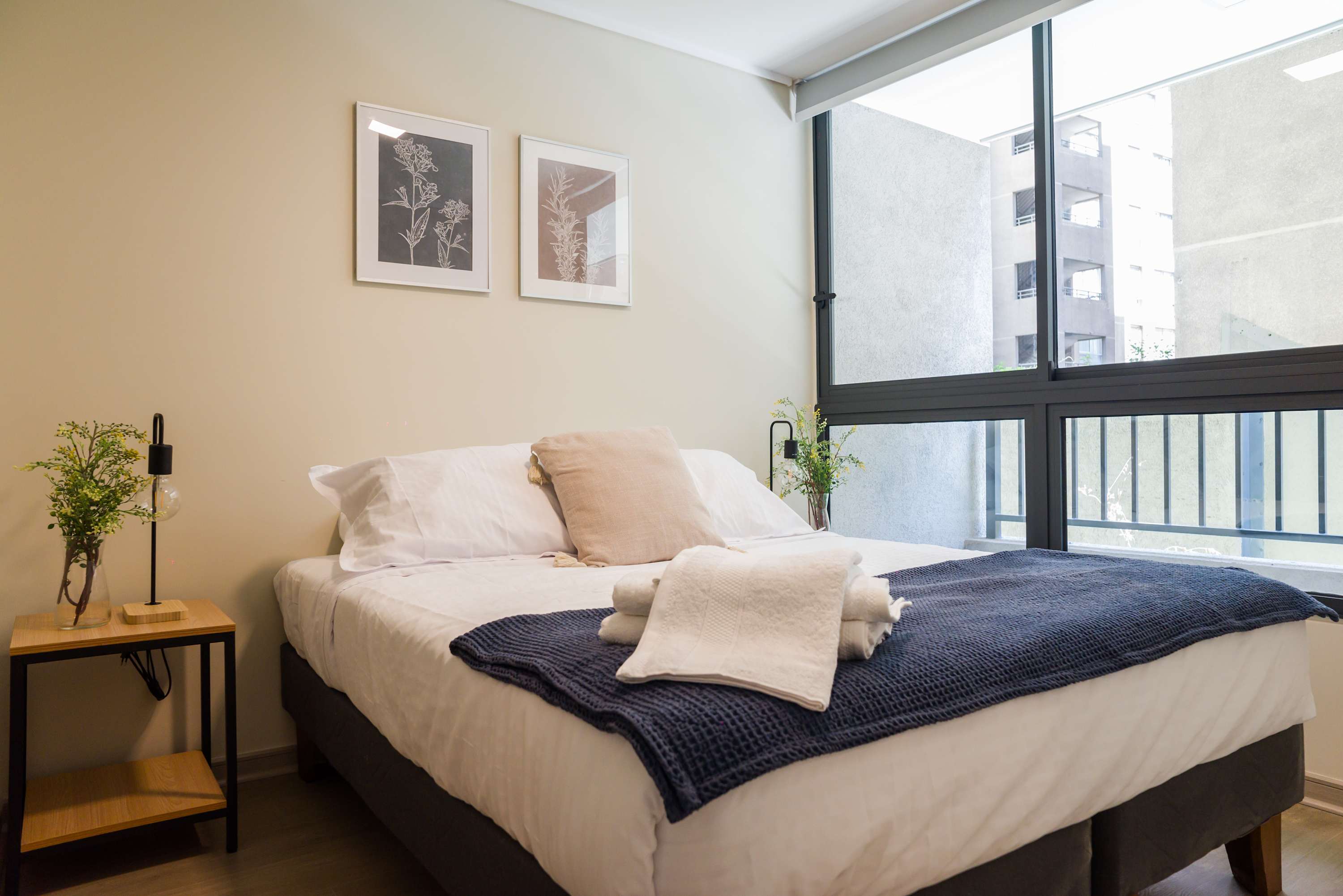 Cozy bedroom with natural light and stylish decor, perfect for a relaxing stay in the heart of the city.