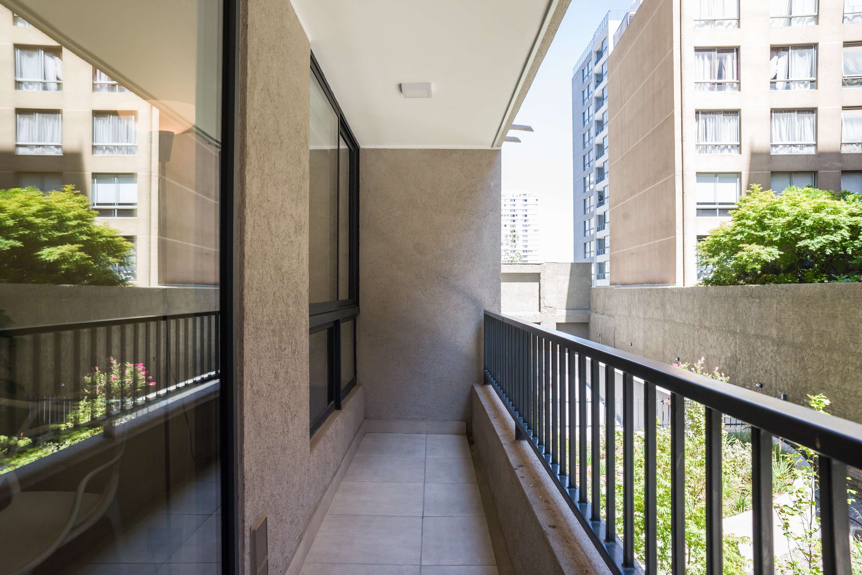 Enjoy a peaceful retreat on your private balcony with city views and lush greenery.