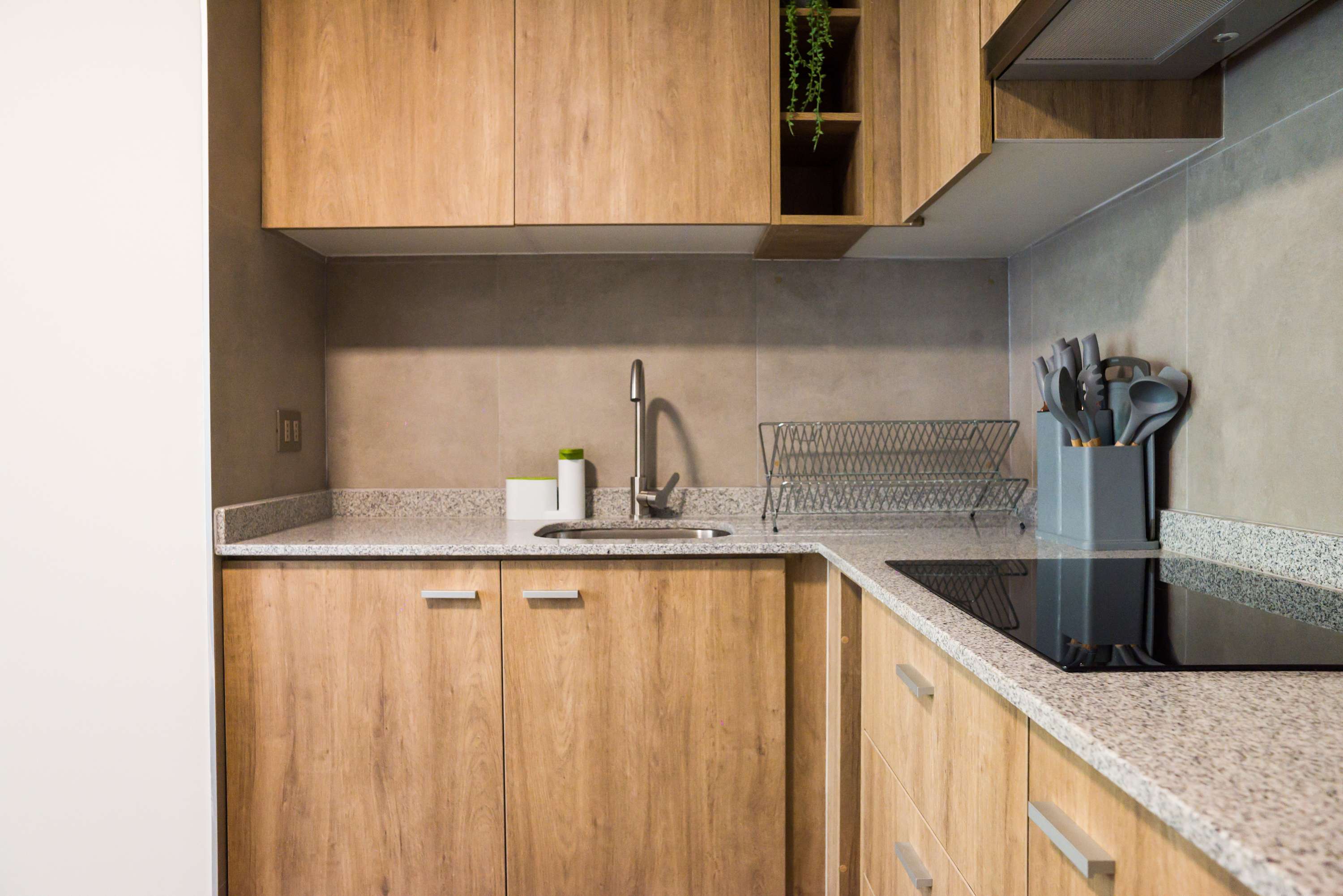 Modern kitchen with sleek wooden cabinets and granite countertops, perfect for preparing meals during your stay.