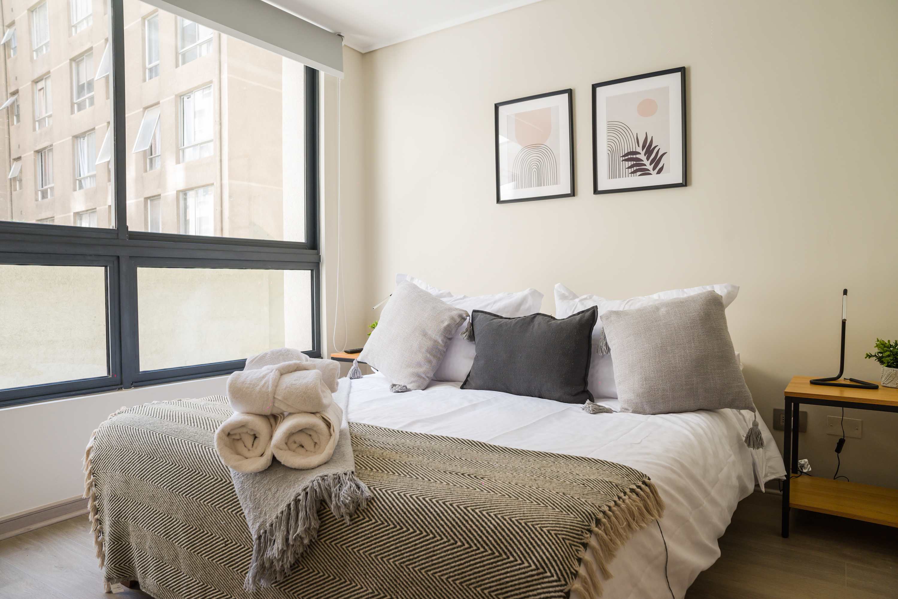 Cozy bedroom with natural light and stylish decor, perfect for a restful stay in the heart of the city.