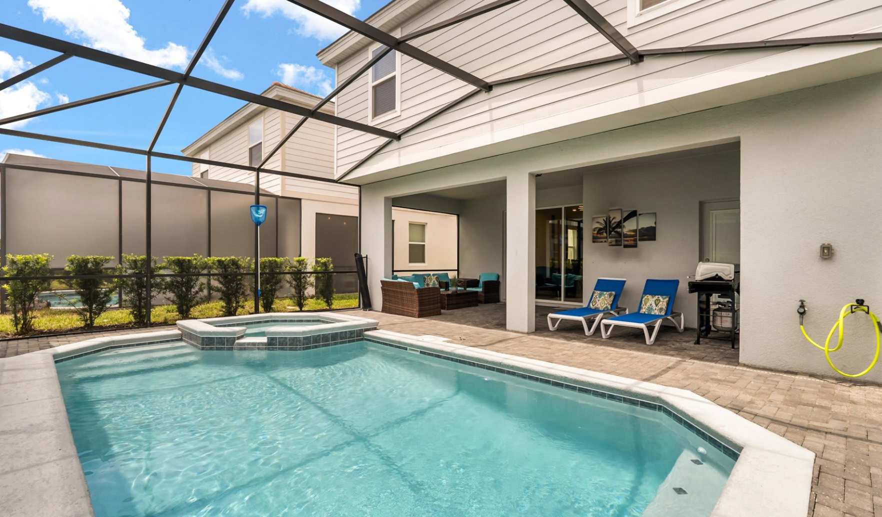 Outdoor screened-in pool with a hot tub