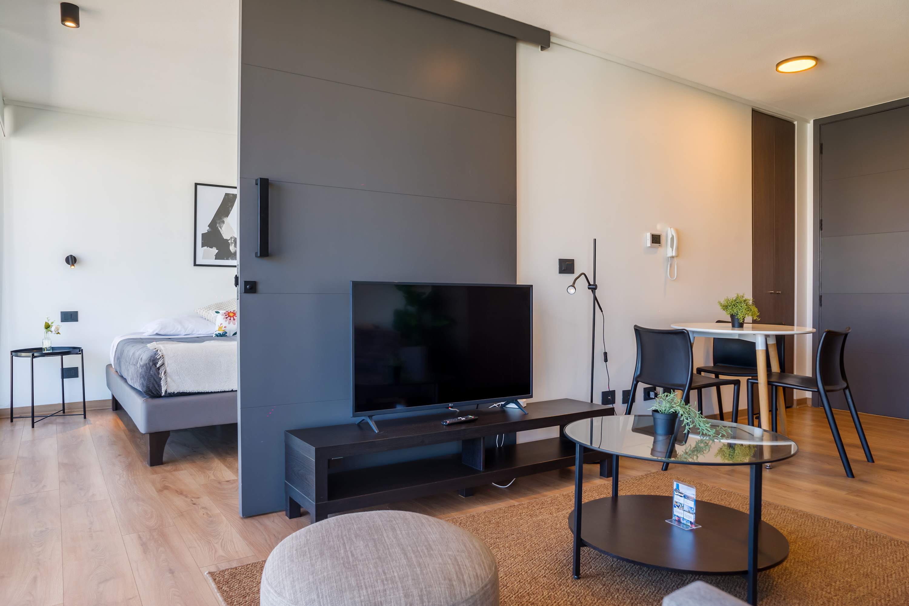 Modern living space with cozy seating, sleek TV setup, and dining area, perfect for relaxation and entertainment.