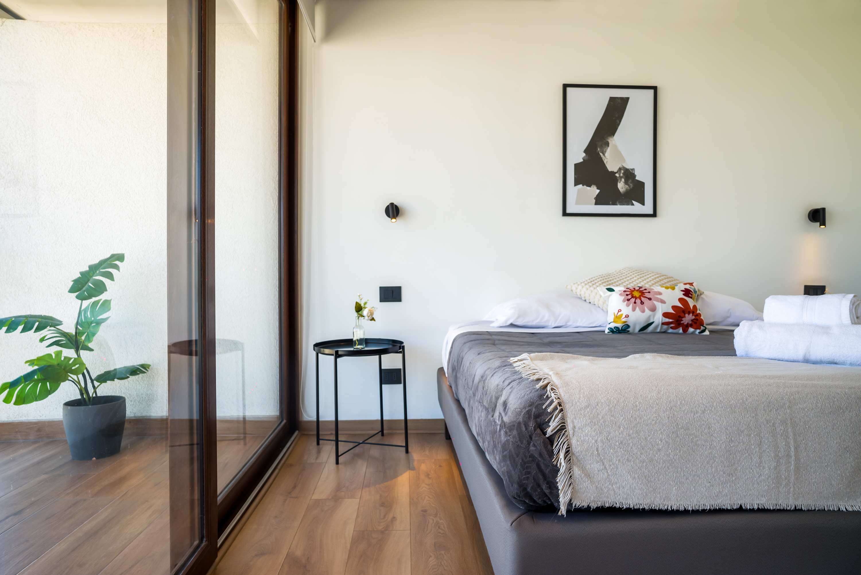 Relax in this stylish bedroom with natural light and modern decor, perfect for a restful stay.