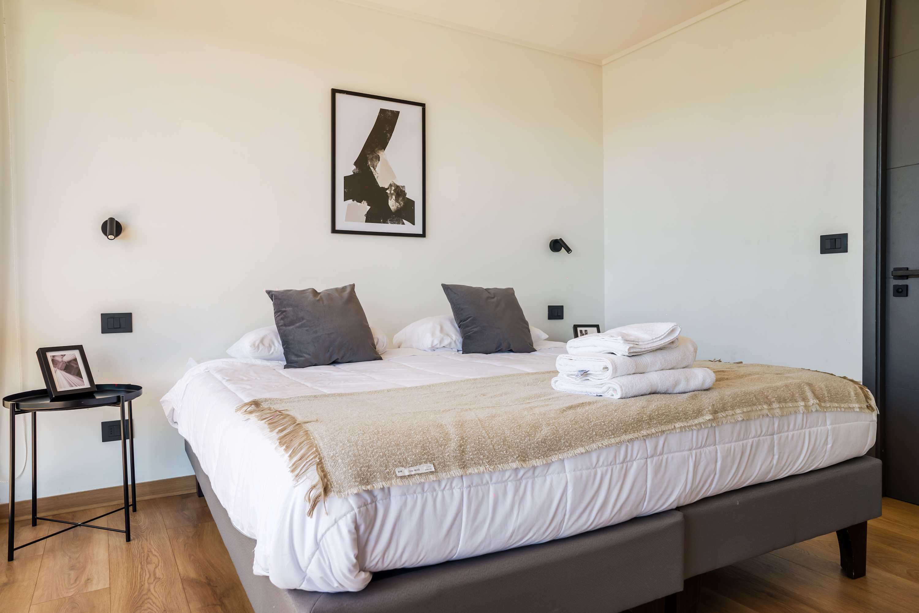 Relax in this cozy bedroom with modern decor and plush bedding, perfect for a restful stay.