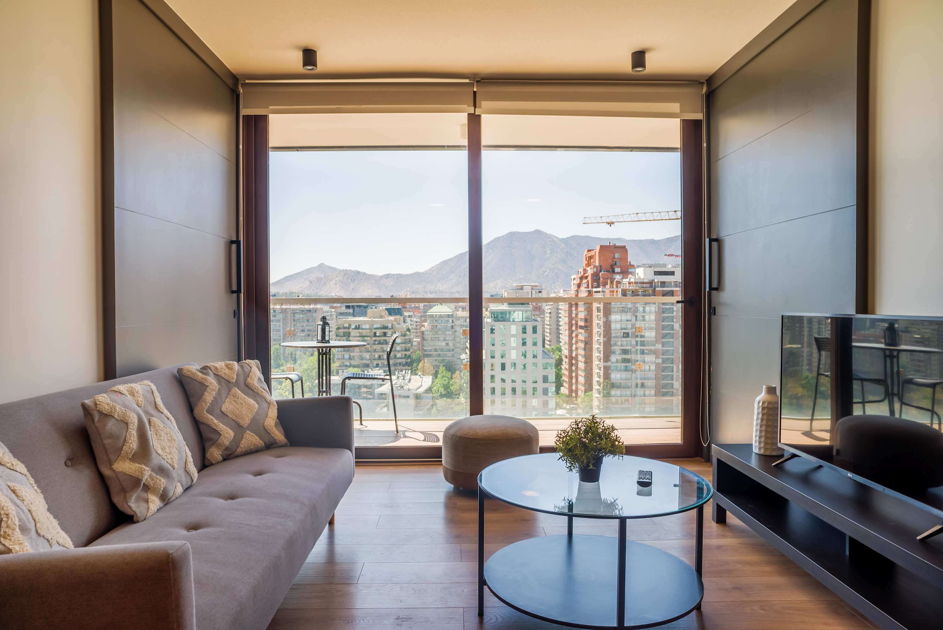Relax in a stylish living room with breathtaking city and mountain views from the comfort of your private balcony.