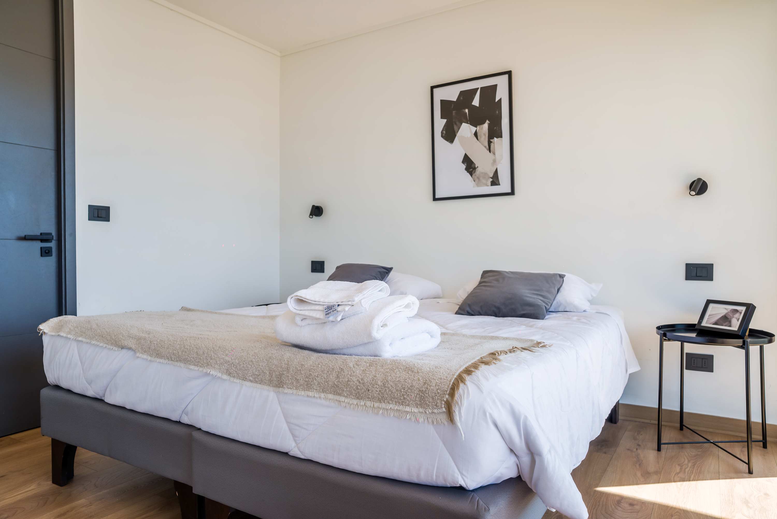 Relax in this cozy bedroom with modern decor and natural light, perfect for a restful stay.