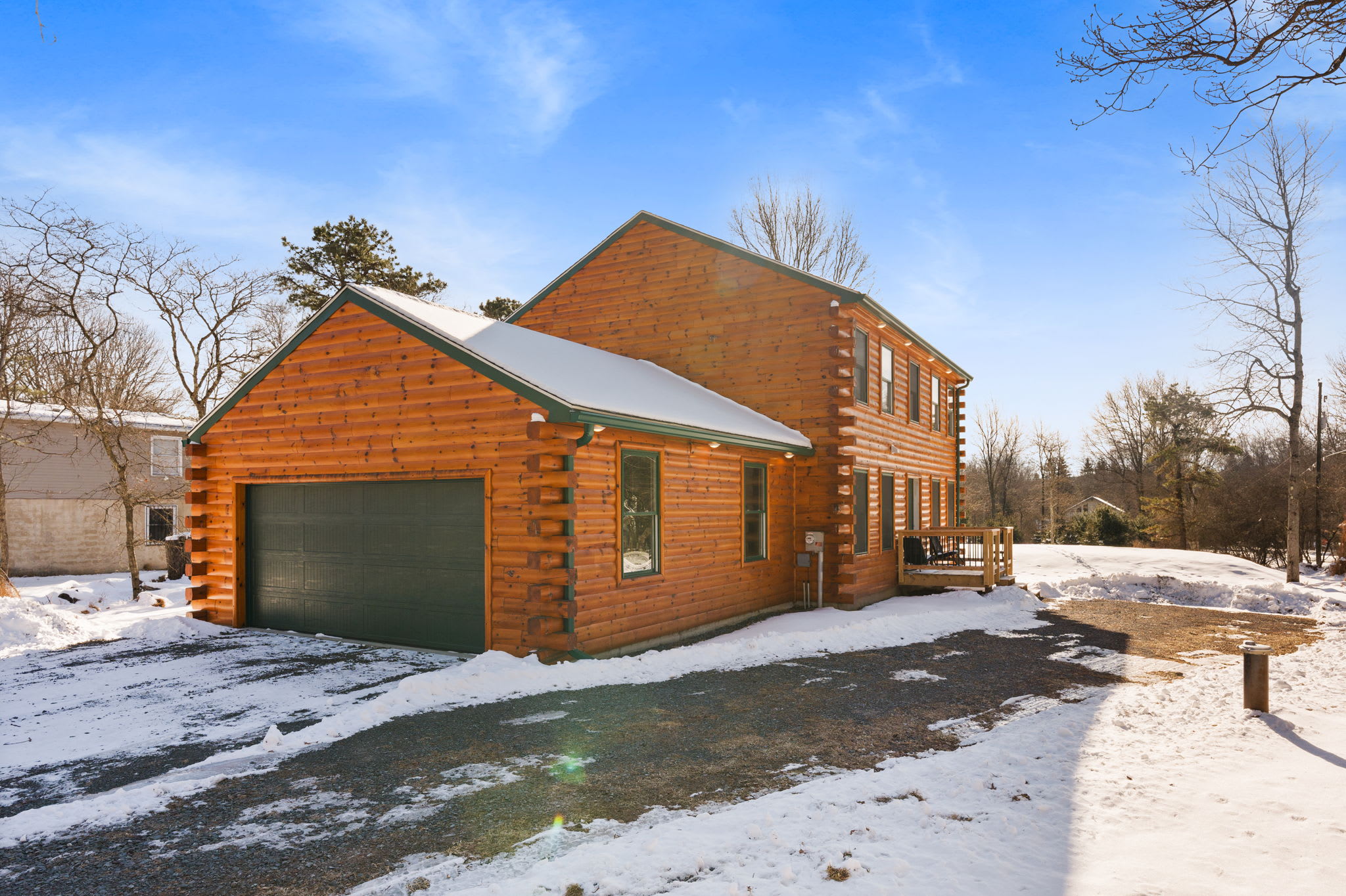 A side view of the Poconos log cabin with garage and plenty of yard space