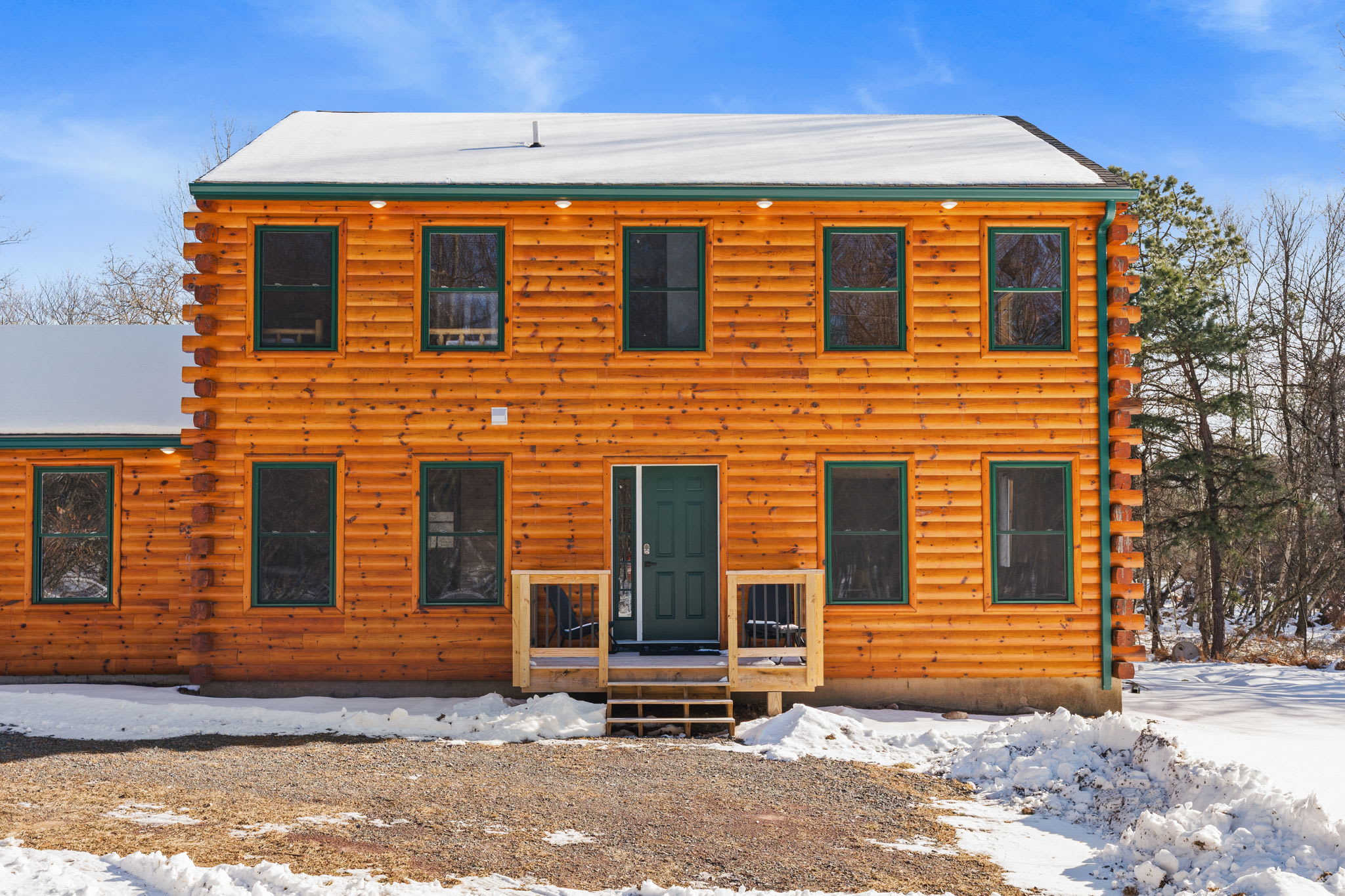 The front of the cabin welcomes you with classic log construction and a wooded setting