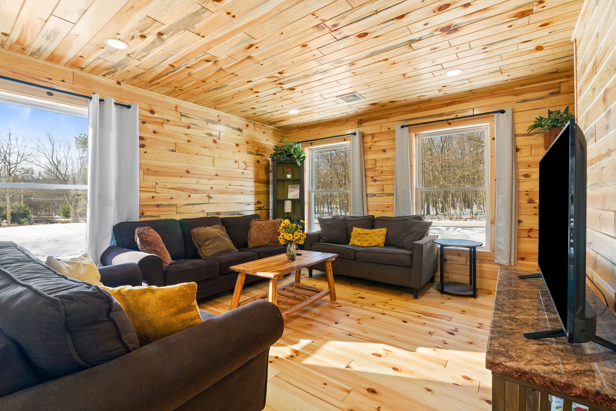 Natural light pours through the large windows with snowy woodland views in the living room