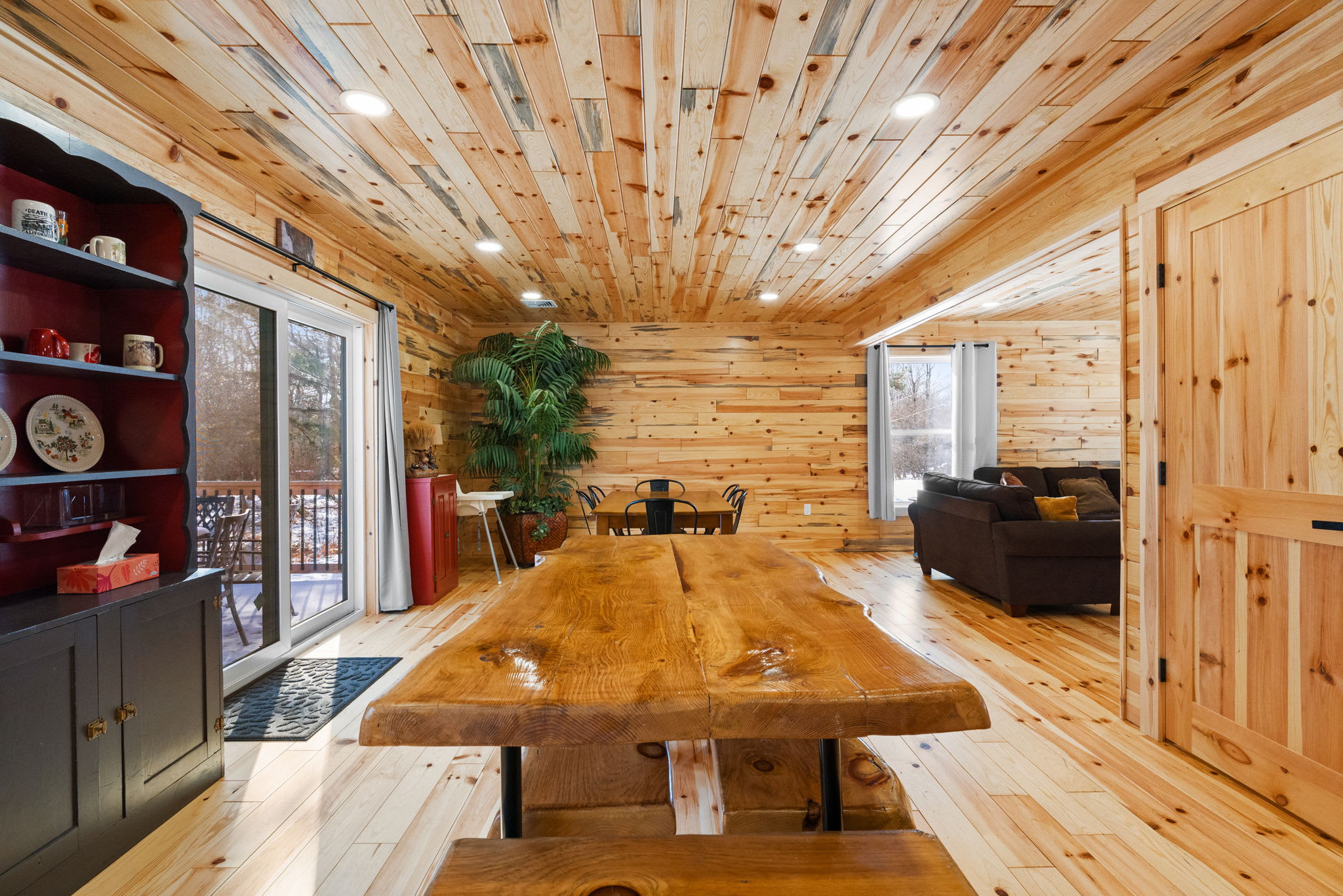The dining area opens to the living room with views of the surrounding woods