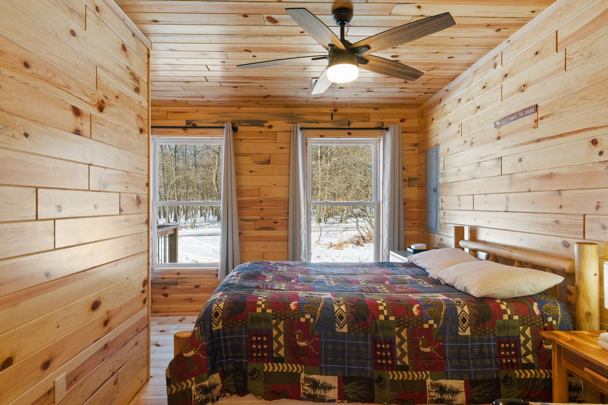 Drift off in this cozy bedroom with a rustic log bed and woodland views from every window