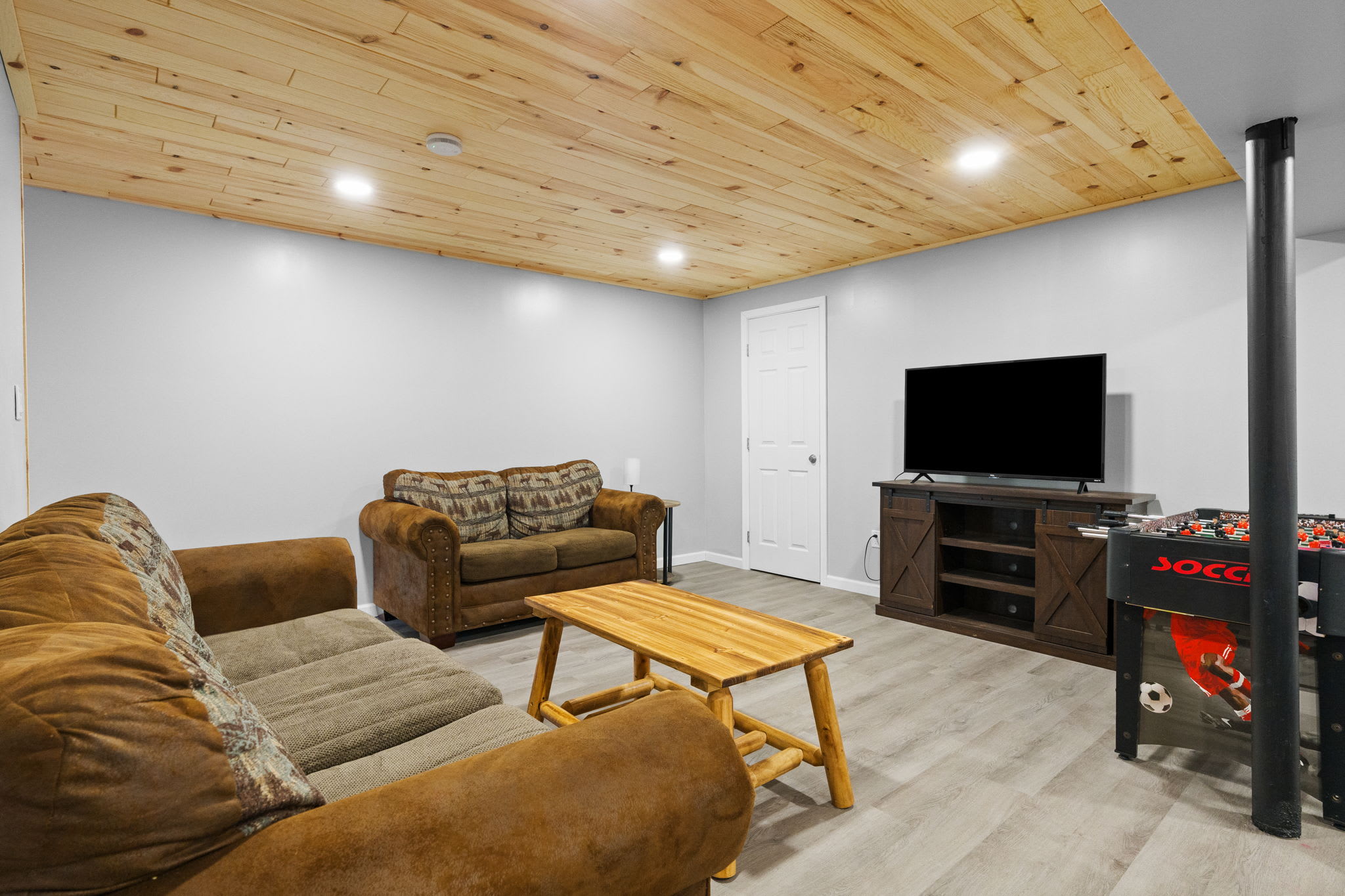 Unwind in the lower-level game room with cozy seating and arcade fun